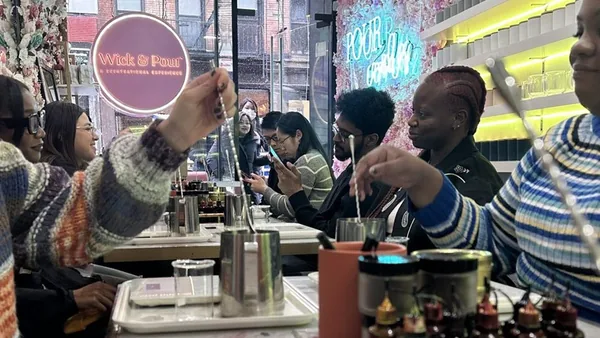 Team measuring fragrance oils together at a corporate candle making event at Wick & Pour NoLita
