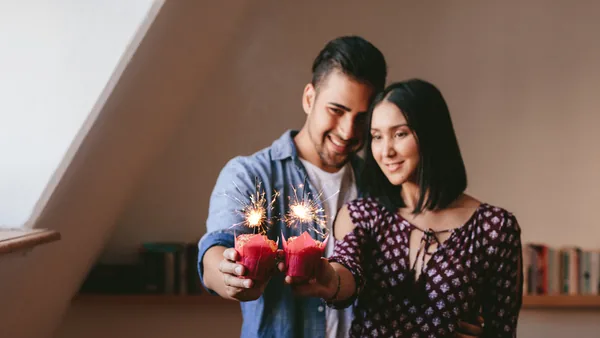 Couple holding glowing candles with sparklers