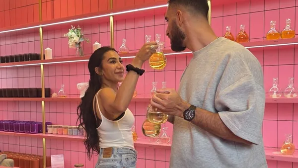 Couple smelling fragrance oils together at the pink scent bar in Wick & Pour's West Village studio