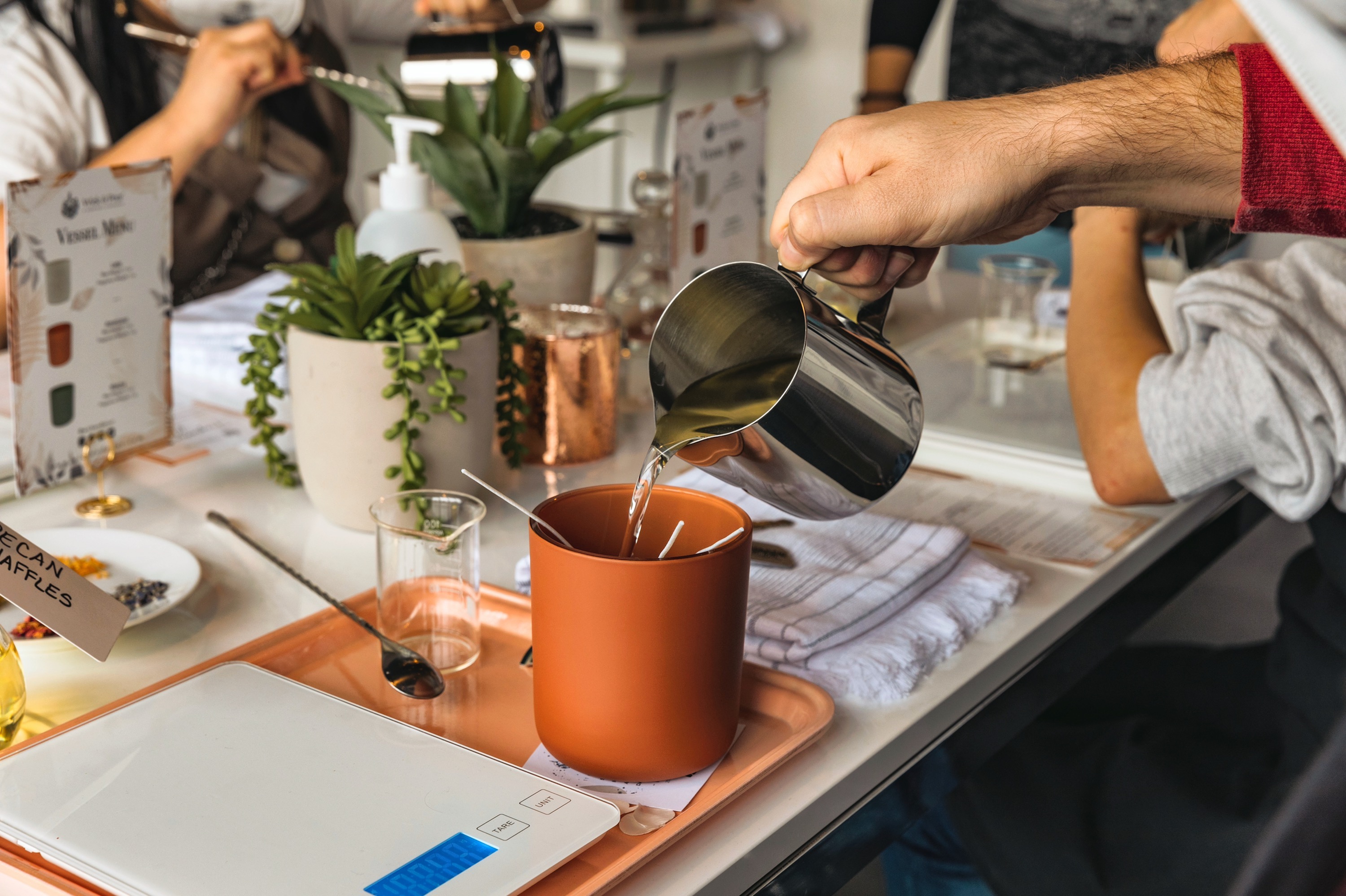 Corporate team pouring wax at an off-site candle making event hosted by Wick & Pour in NYC