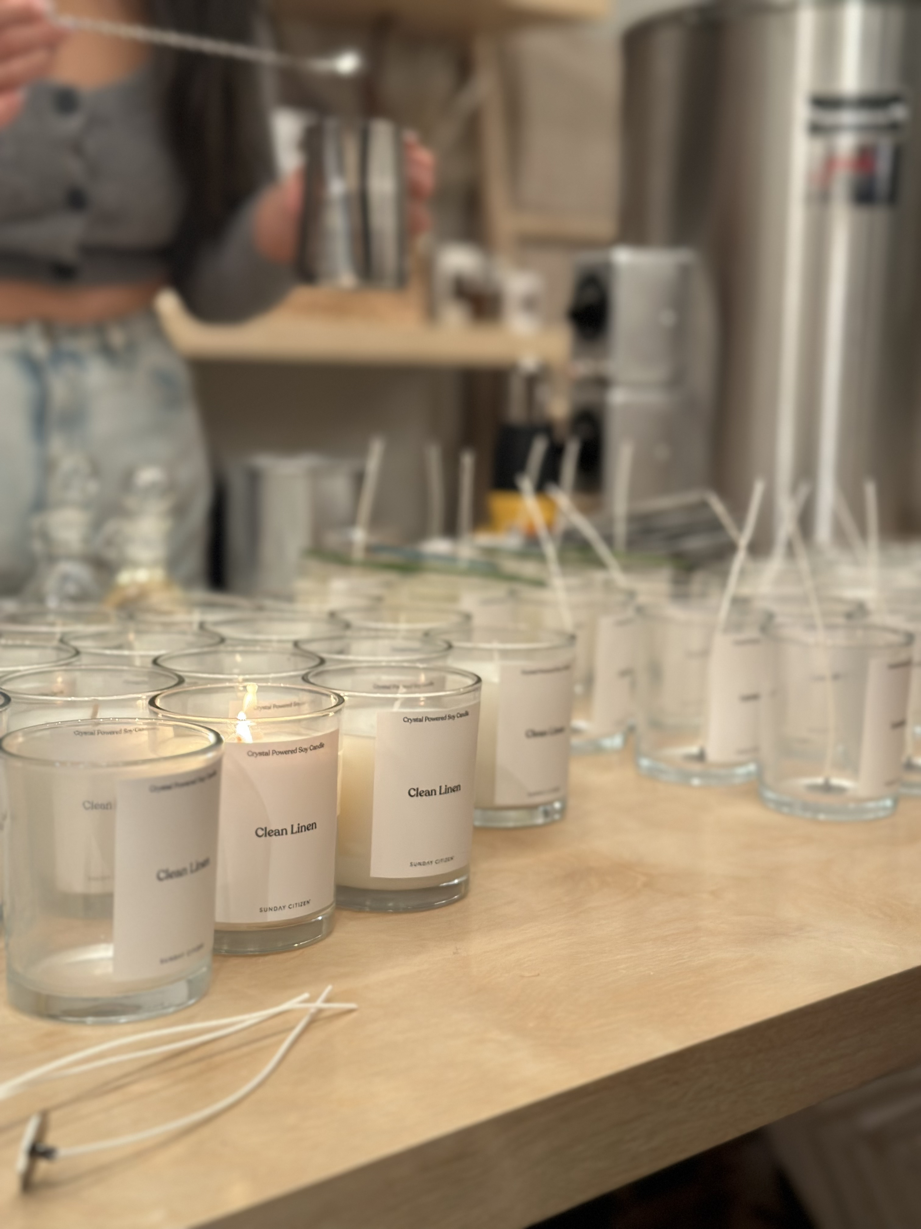 Rows of glass candle vessels with wicks set up for a Wick & Pour off-site corporate event