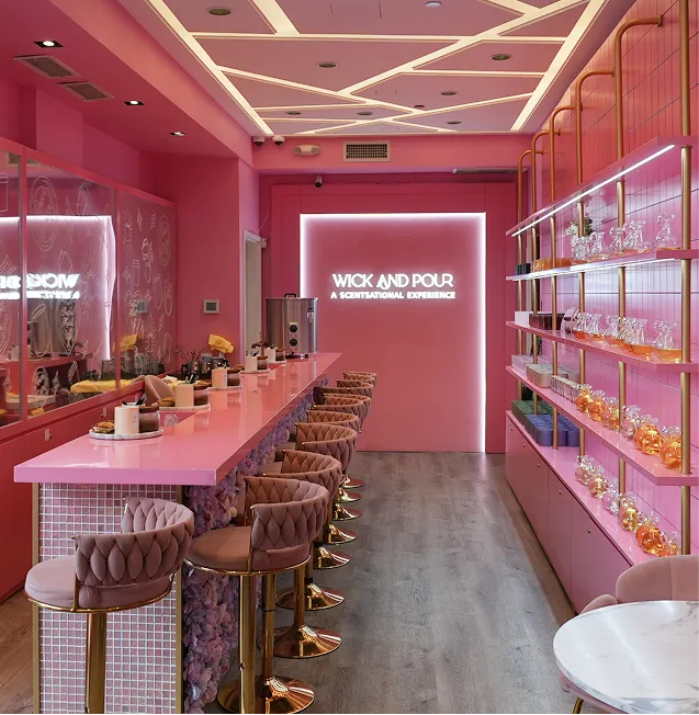 Wick & Pour West Village studio on Bleecker Street, with a pink pour bar, velvet stools, and shelves of fragrance oils