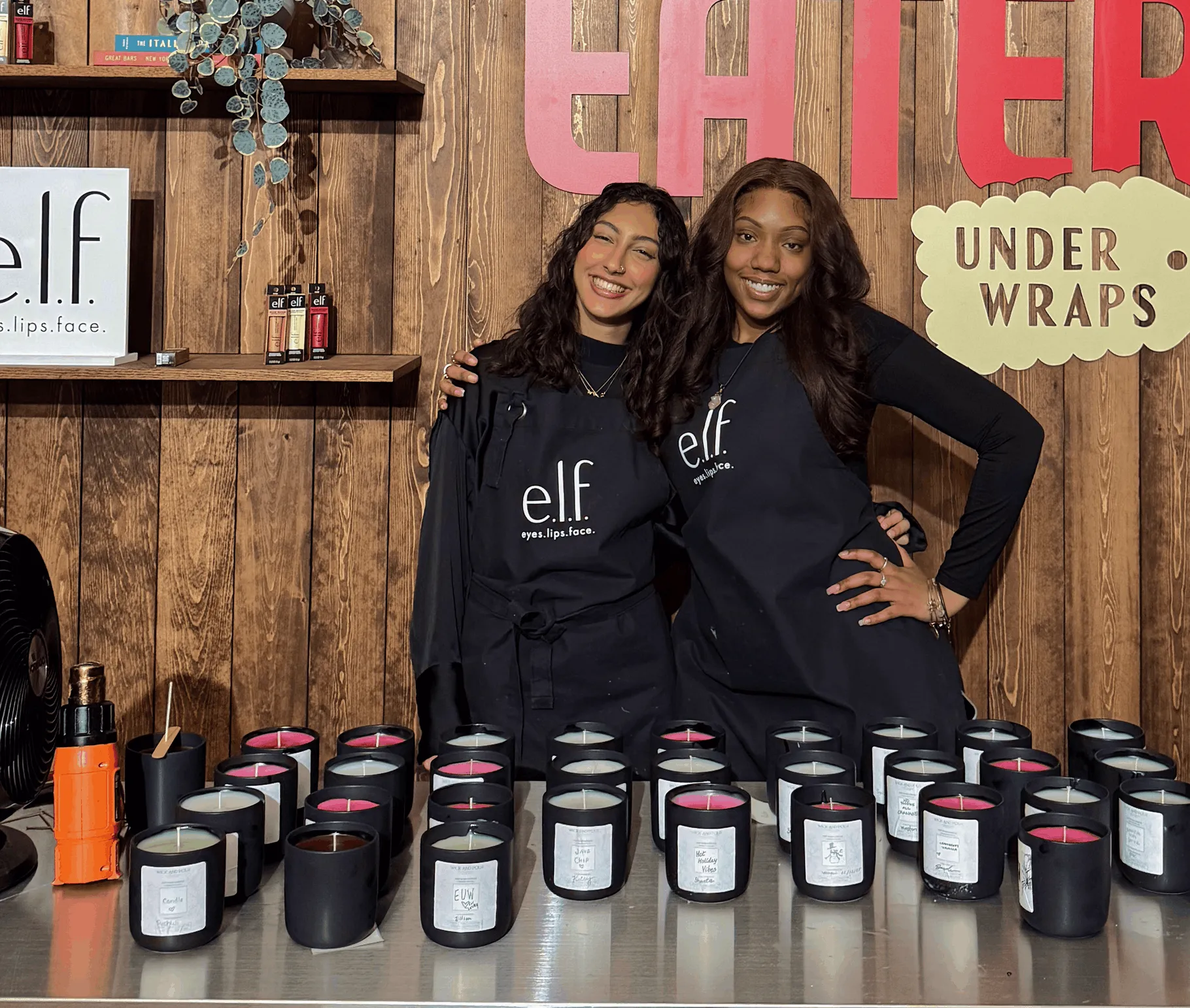 Wick & Pour off-site brand activation for e.l.f. Cosmetics: two hosts behind a table of custom-poured candles