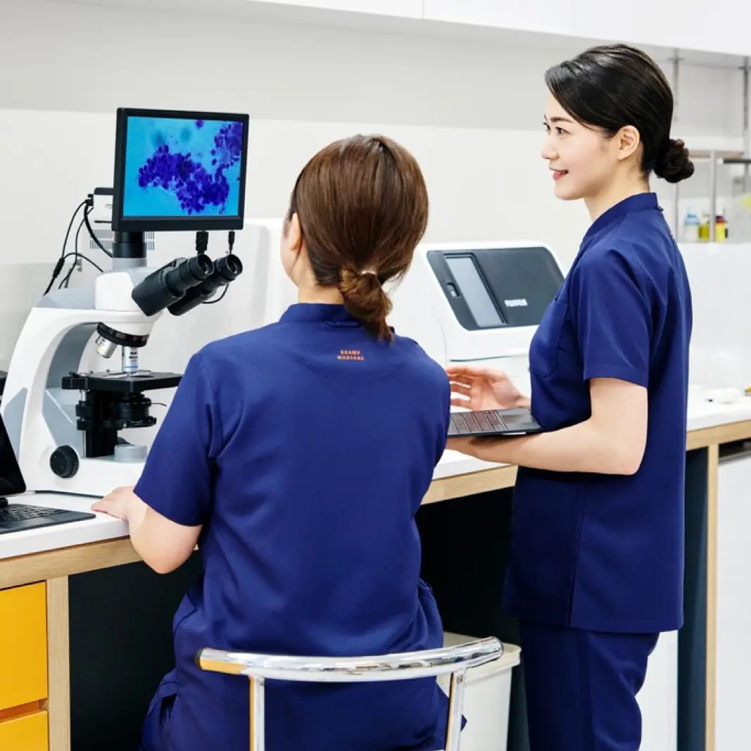 検査室で顕微鏡の所見を確認するスタッフ