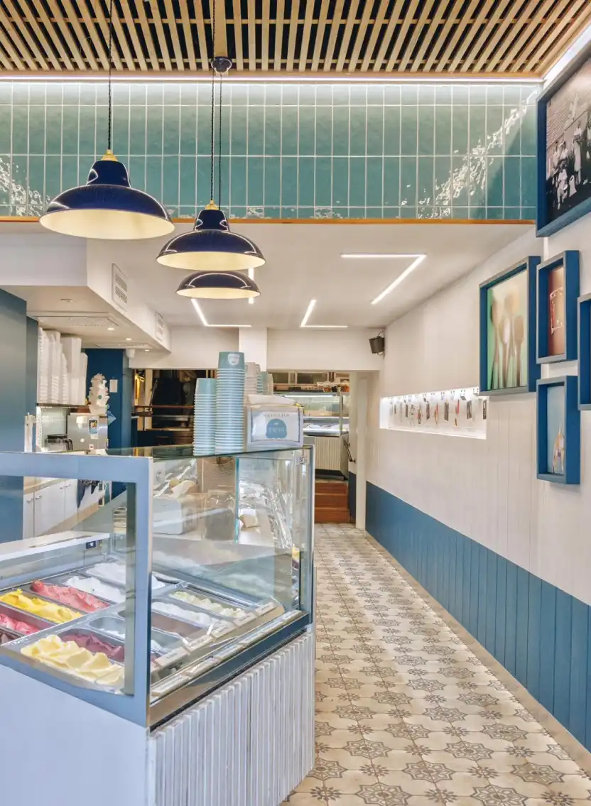 Intérieur du glacier Raugi à Bastia : vitrine à glaces, carrelage à motifs et lambris bleu