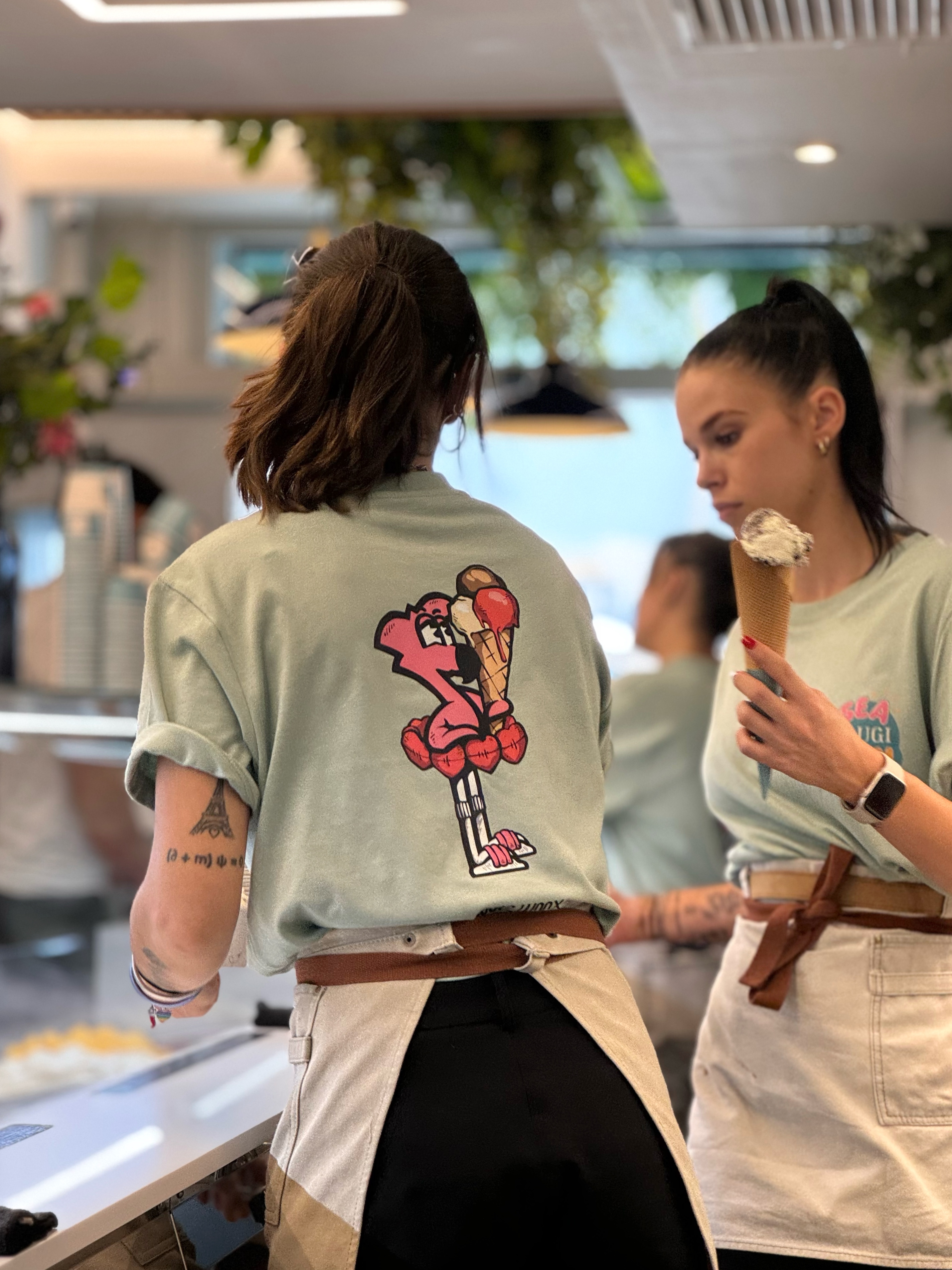 Équipe du glacier Raugi en t-shirts à l'effigie de Roger le Flamant Rose, pendant le service