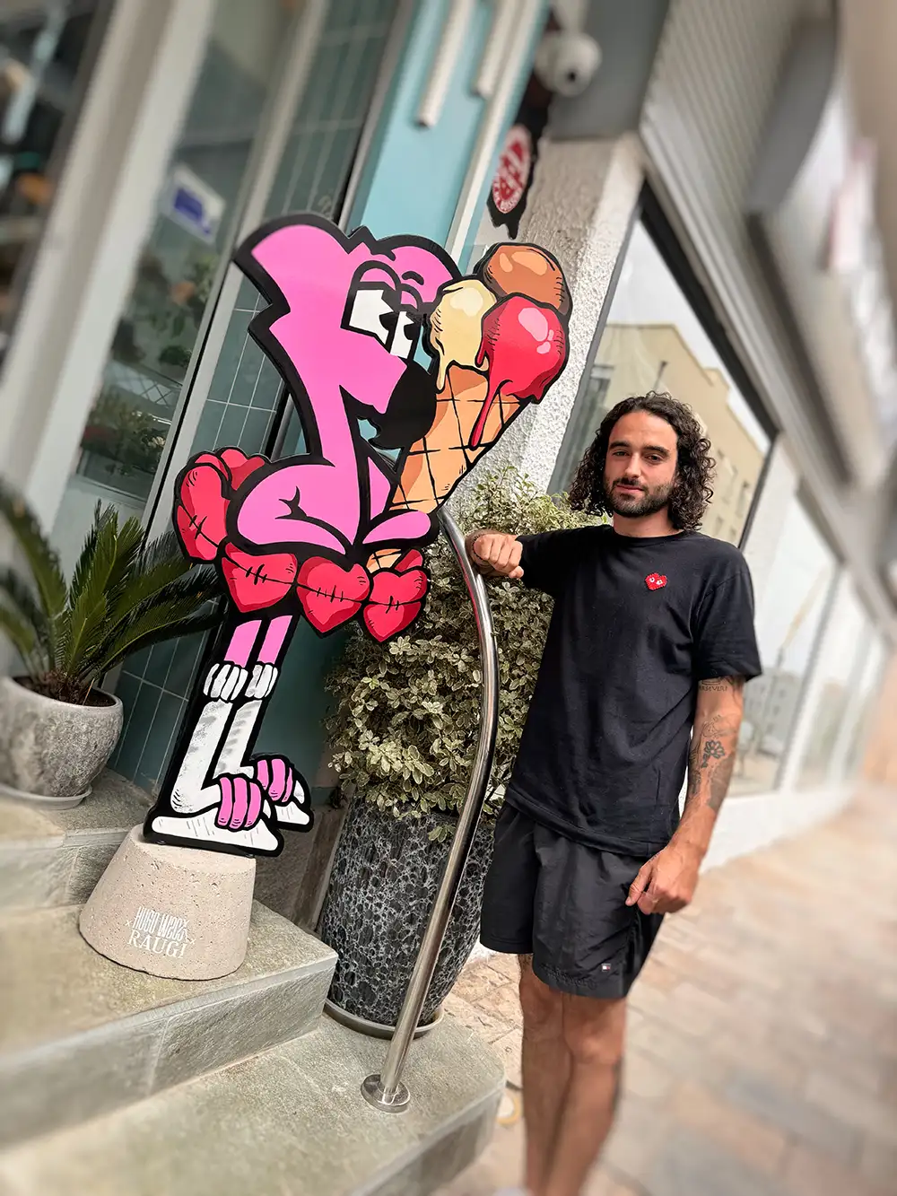 Hugo W2CJ devant la sculpture en bois de Roger le Flamant Rose, installée à l'entrée du glacier Raugi