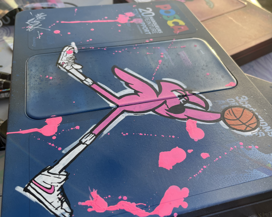 Mallette Posca bleue customisée : flamant rose au dunk, ballon de basket et éclaboussures roses