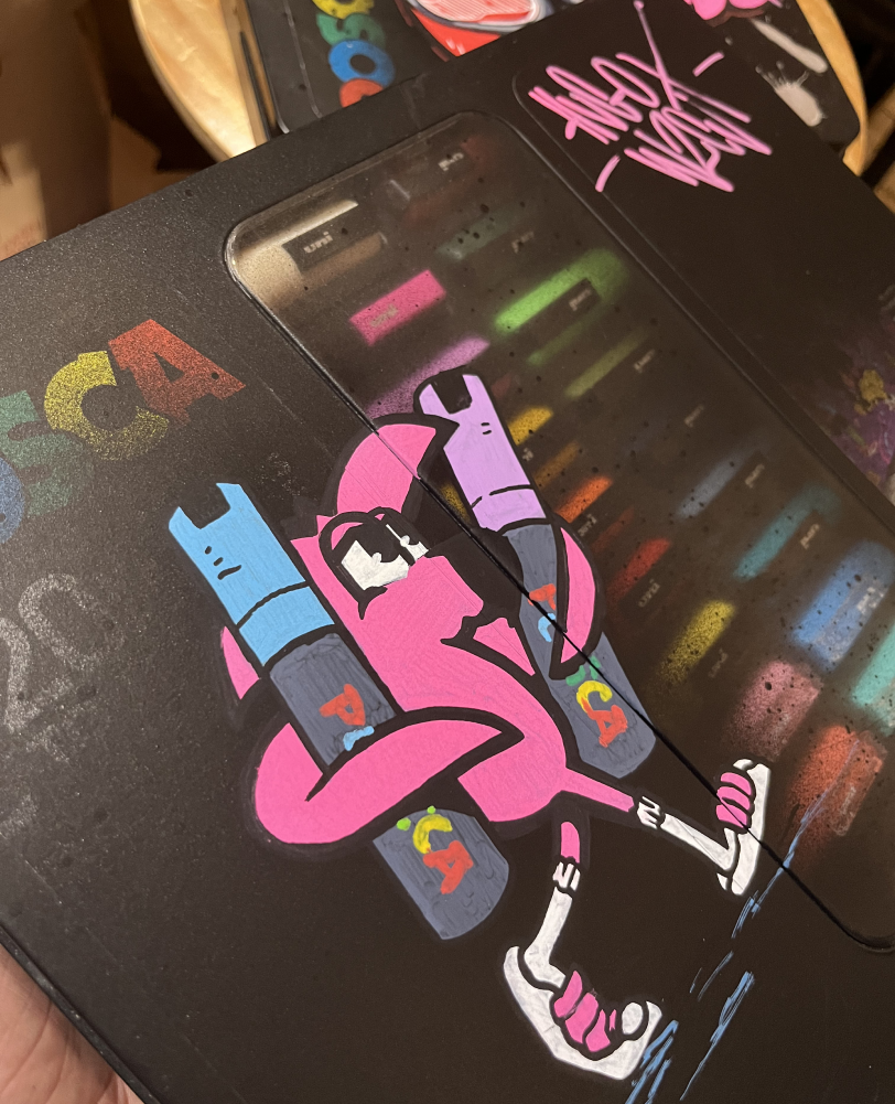 Mallette Posca noire customisée : flamant rose jonglant avec des marqueurs de couleur