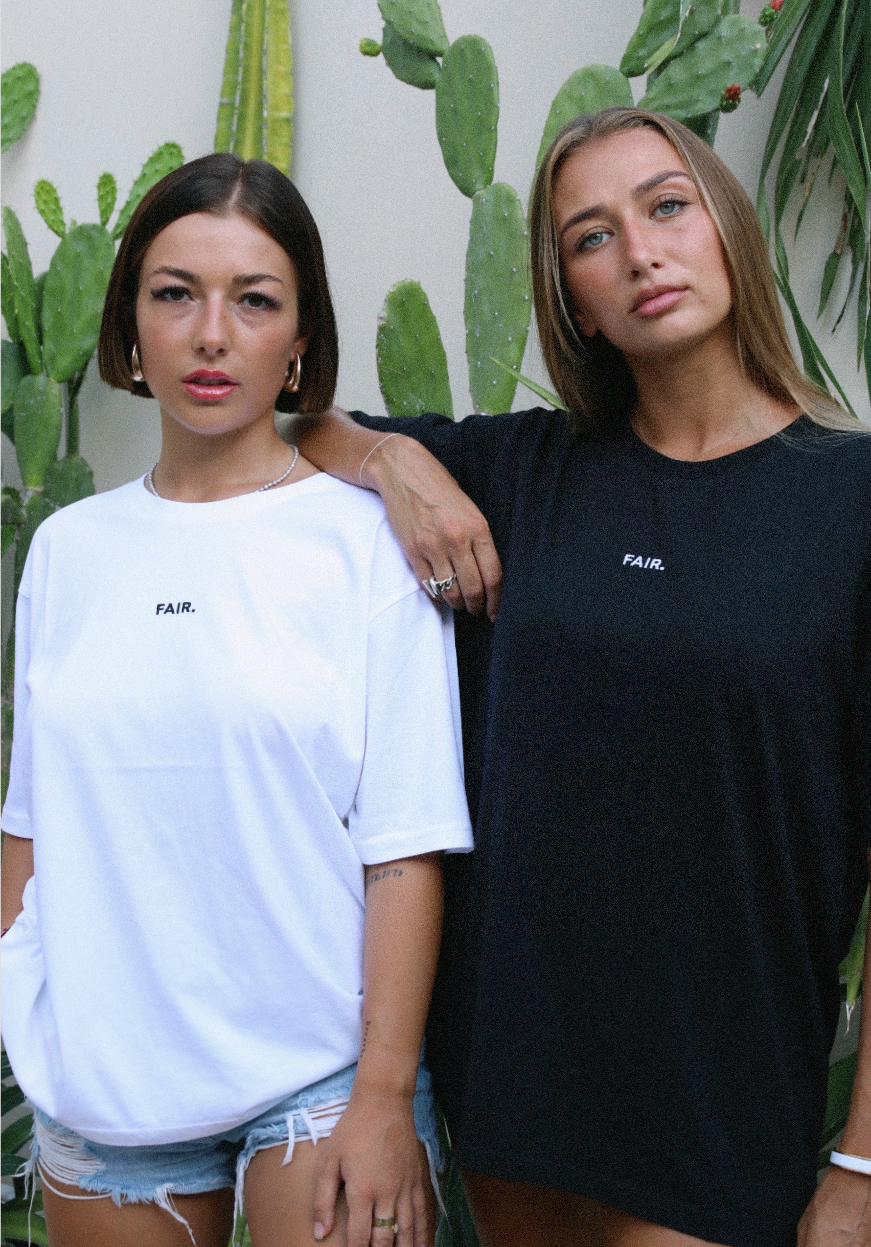 T-shirts Fair blanc et noir portés devant des cactus, logo brodé sur la poitrine