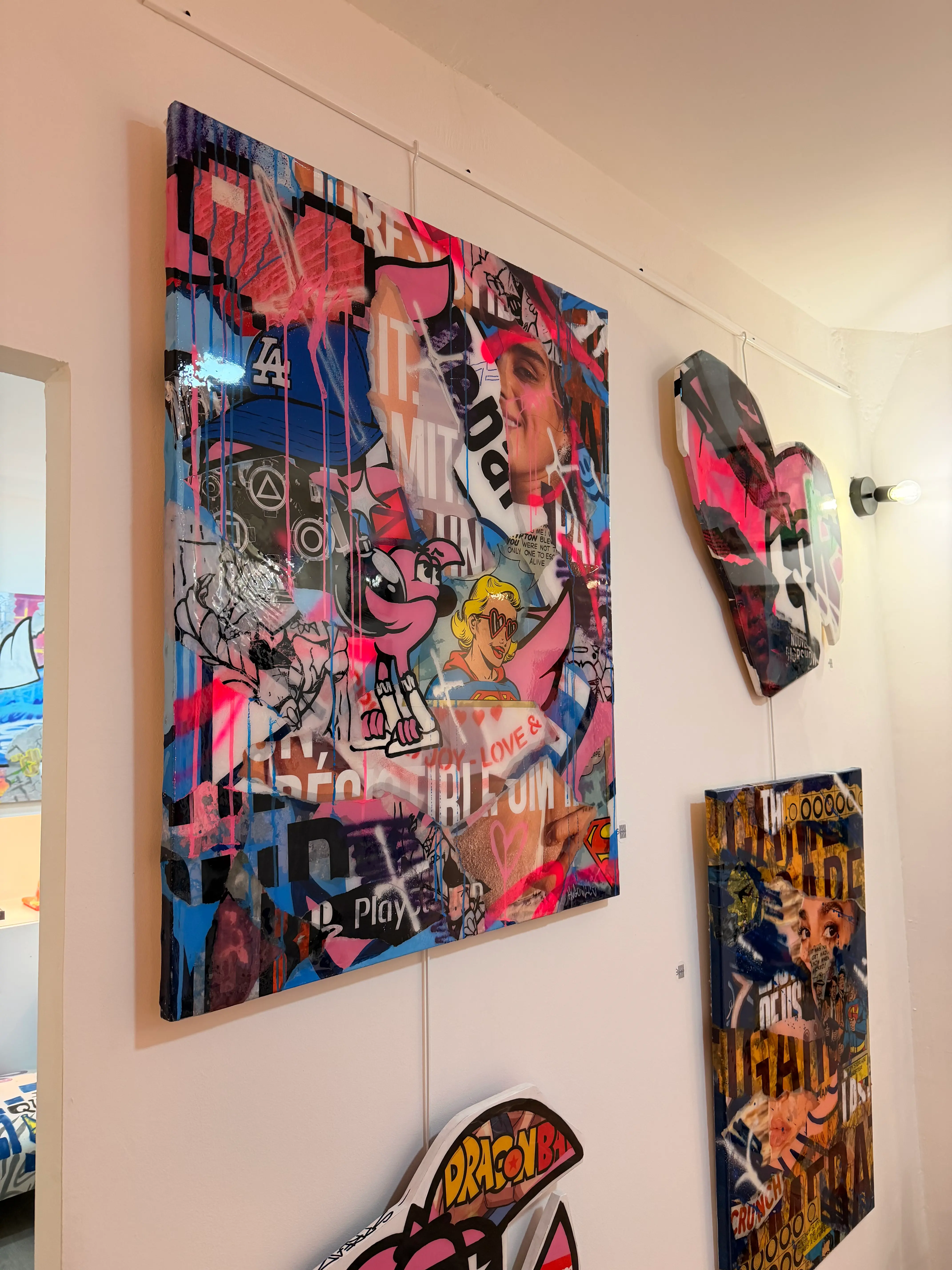 Grande toile en collage d'affiches, aérosol et résine, avec Roger le Flamant Rose et des figures pop, accrochée à la Galerie Residenza