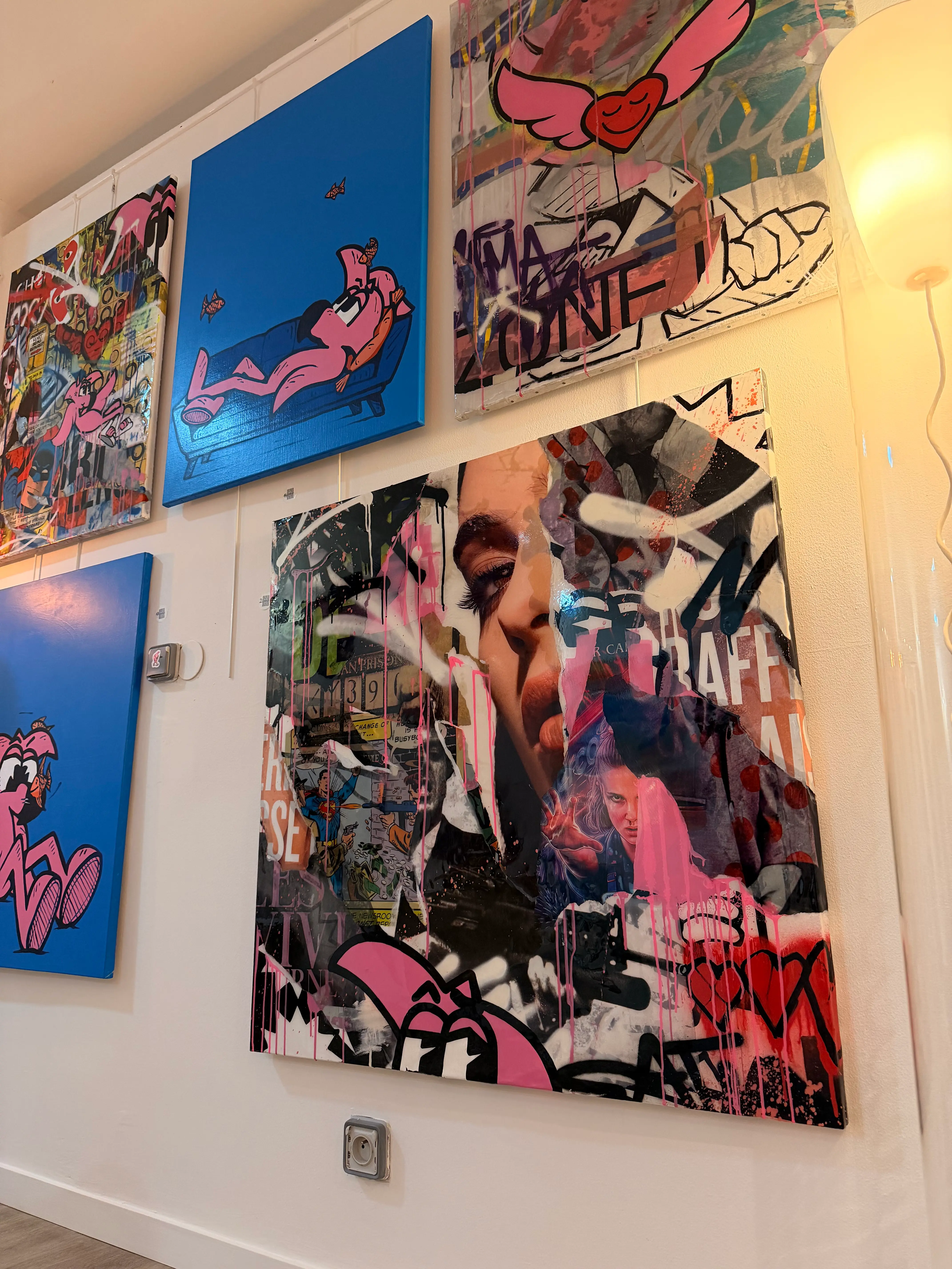 Grand portrait de femme en collage d'affiches lacérées, accroché sous les toiles bleues de Roger le Flamant Rose
