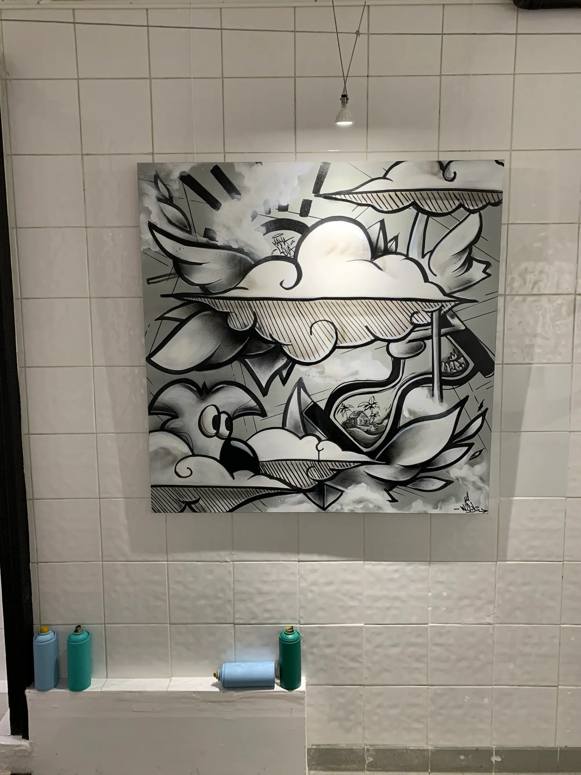 Exposition à la galerie Noir & Blanc, 2020 : toile en noir et blanc, nuages, ailes et Roger le Flamant Rose, accrochée sur un mur carrelé