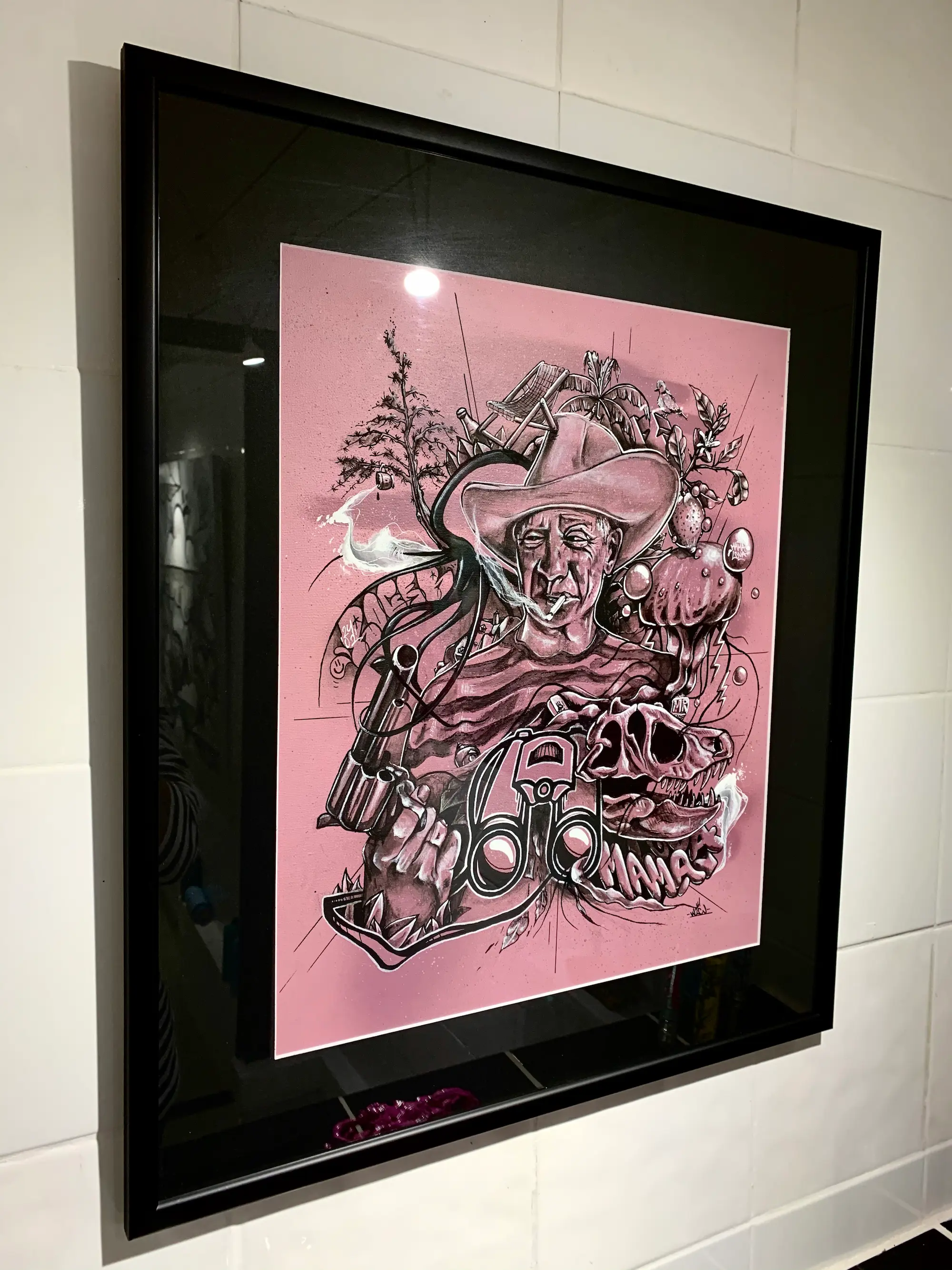 Exposition à la galerie Noir & Blanc, 2020 : œuvre encadrée sur fond rose, portrait en noir et blanc d'un personnage au chapeau de cow-boy entouré de motifs