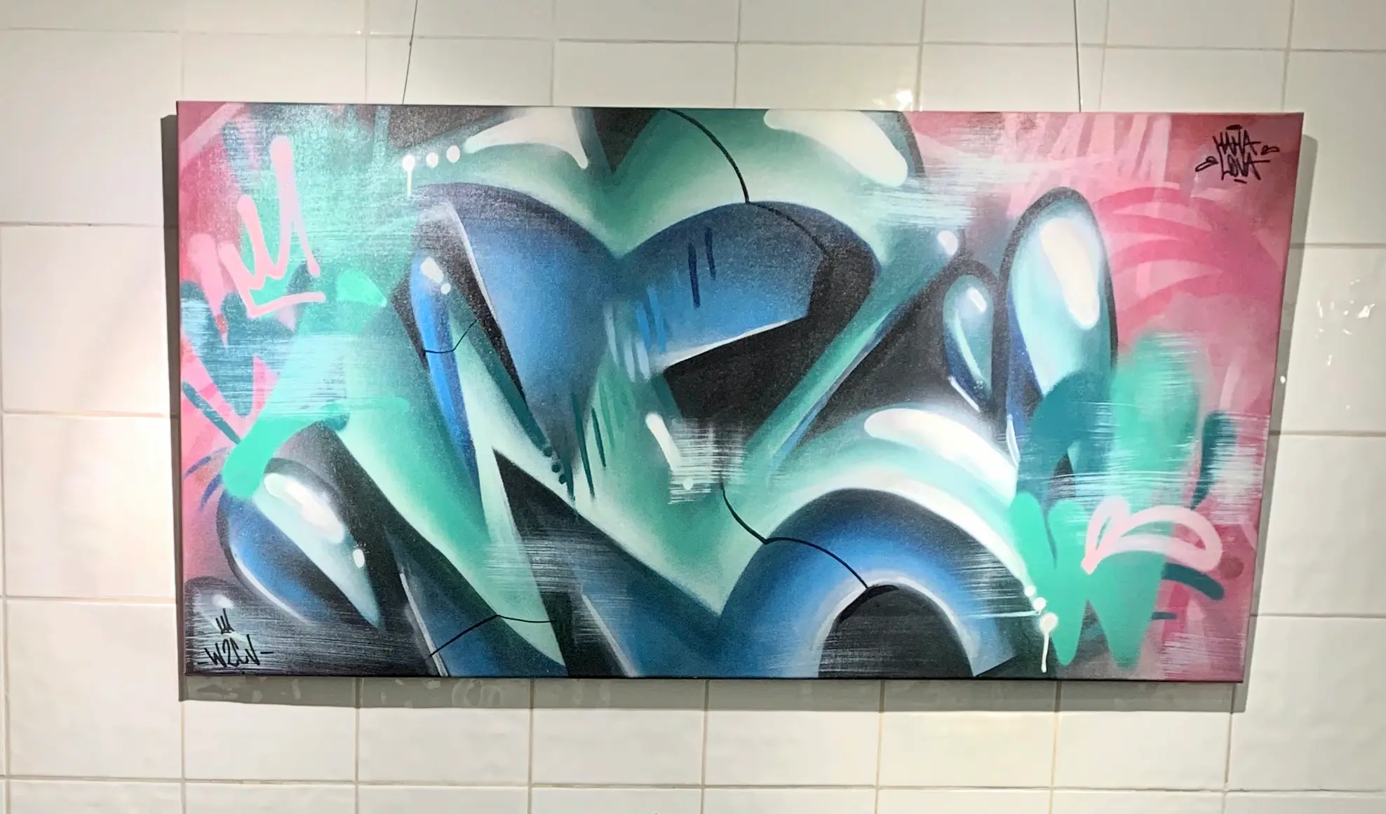 Exposition à la galerie Noir & Blanc, 2020 : toile graffiti en lettrage bleu et turquoise sur fond rose, accrochée sur un mur carrelé