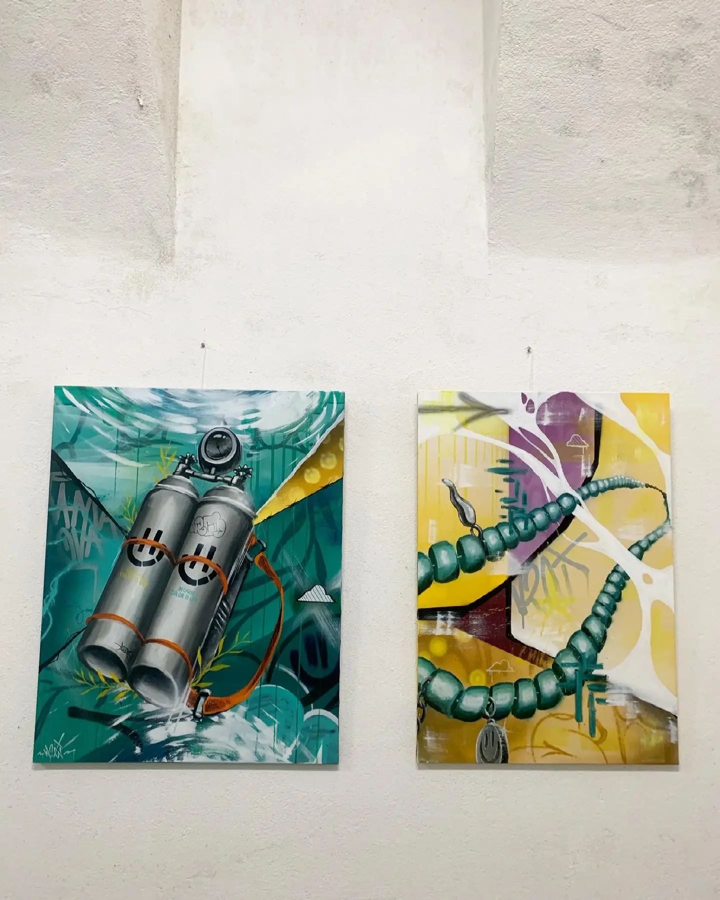 Exposition en duo avec Karma Theora, galerie Noir & Blanc, 2021 : deux toiles accrochées, des bouteilles de plongée souriantes sur fond turquoise et un serpent vert sur fond jaune