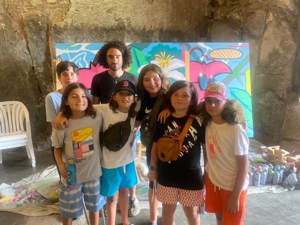 Live painting au festival Calviart, 2022 : l'artiste avec un groupe d'enfants devant la grande toile peinte ensemble
