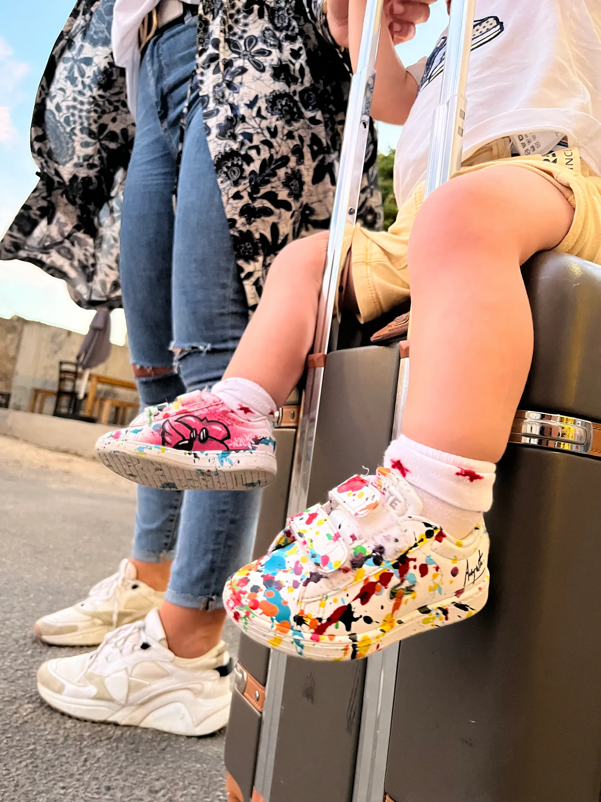 Live painting au festival Calviart, 2022 : baskets d'enfant peintes de taches multicolores, posées sur une valise