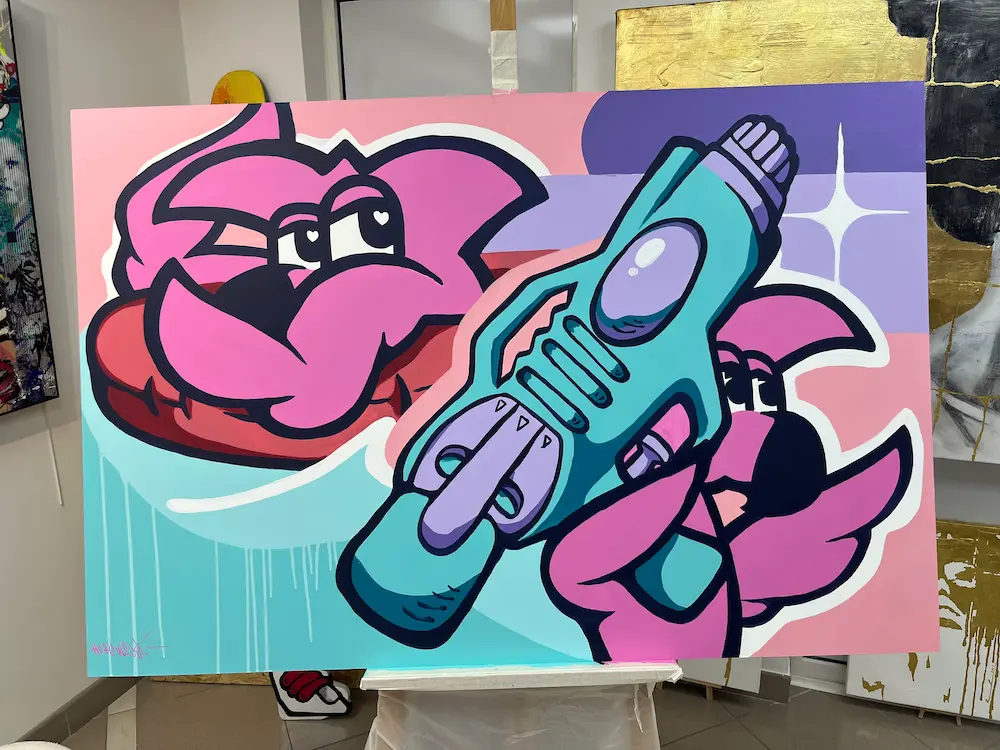 Live painting à la galerie Bel'arti, 2024 : toile sur chevalet, deux Roger le Flamant Rose roses et un pistolet à eau turquoise sur fond pastel