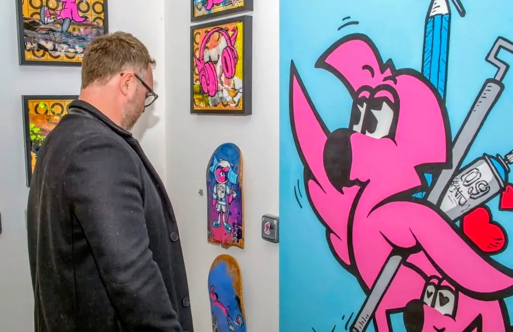 Street Therapy, exposition de Hugo W2CJ, 2026 : visiteur regardant les œuvres, grande toile de Roger le Flamant Rose rose sur fond turquoise