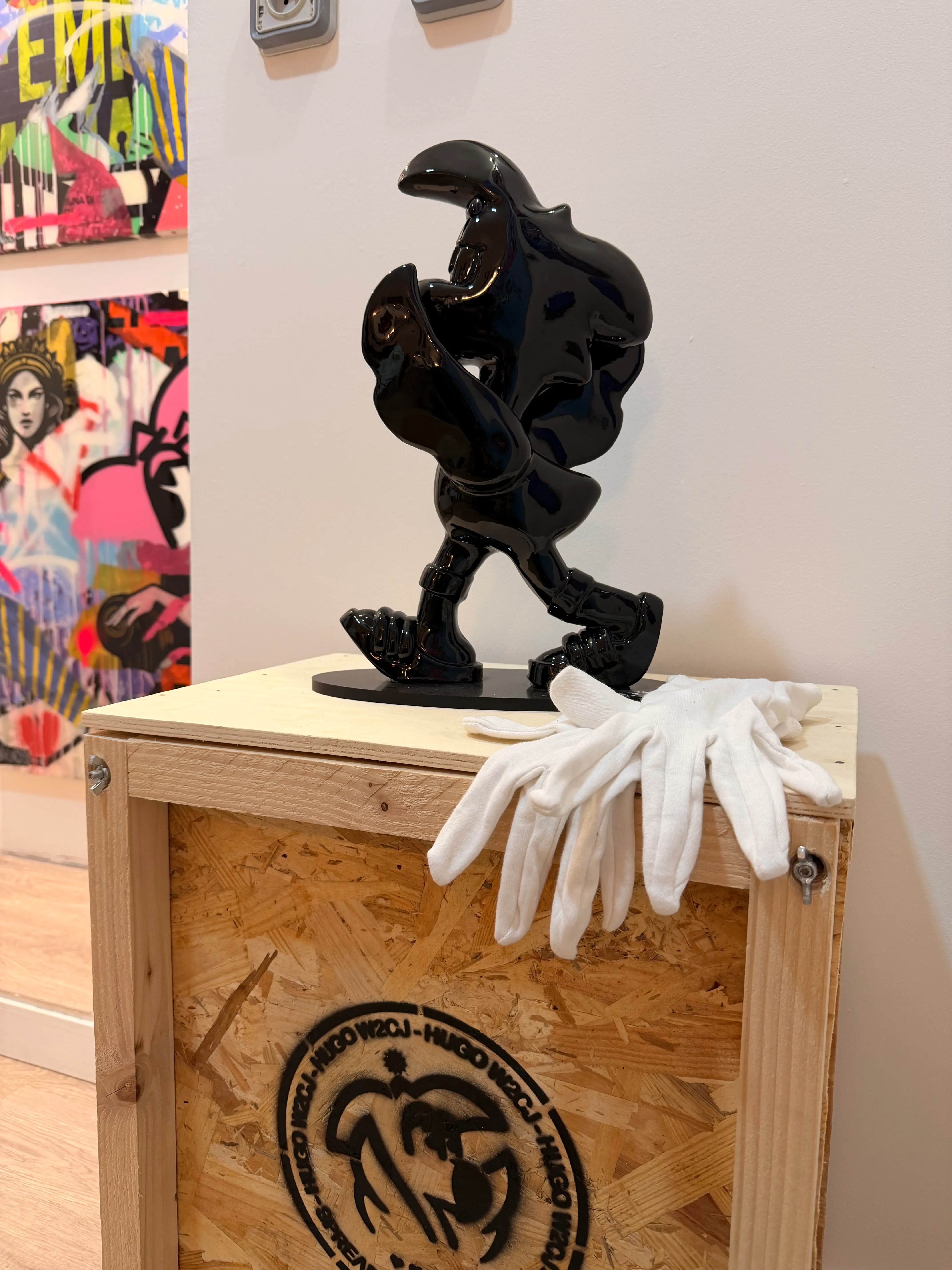 Street Therapy, exposition de Hugo W2CJ, 2026 : sculpture noire de Roger le Flamant Rose sur une caisse en bois, gants blancs posés à côté