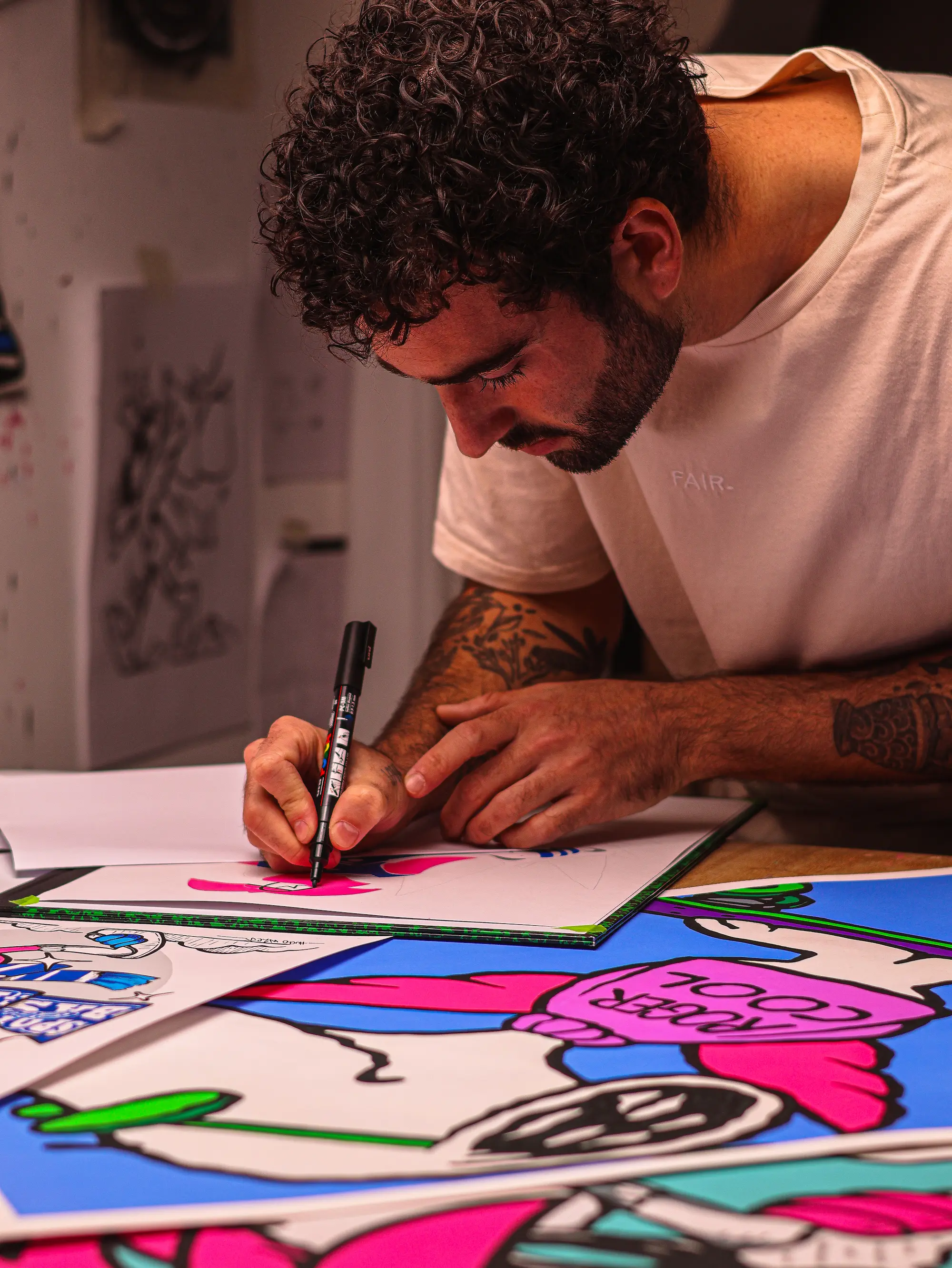 Collaboration Hugo W2CJ x Sporting Club de Bastia : l'artiste penché sur sa table, en train de dessiner au feutre