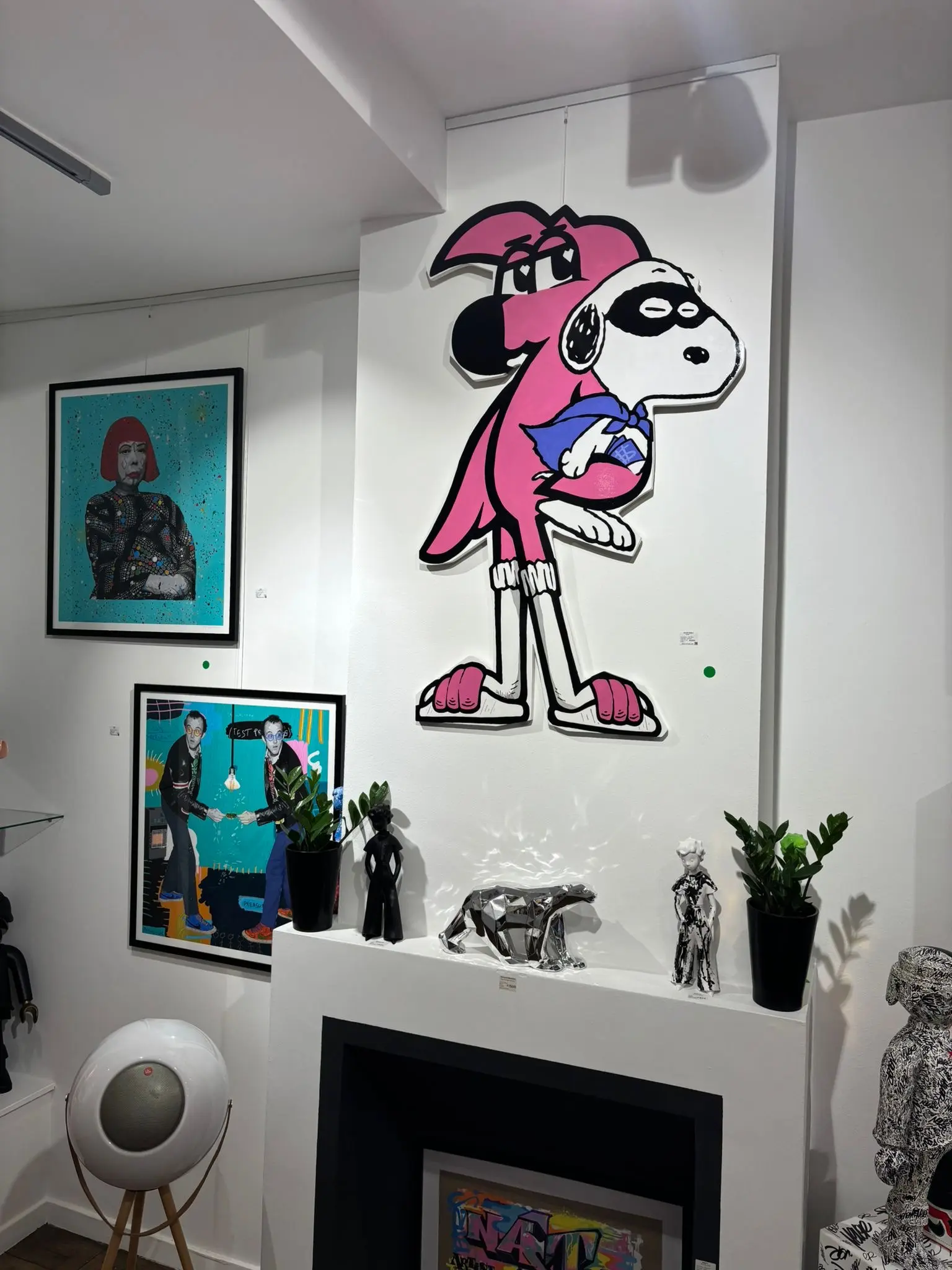 Découpe murale de Roger le Flamant Rose coiffé d'un masque de Snoopy, accrochée au mur de l'Absolute Gallery, Bruxelles