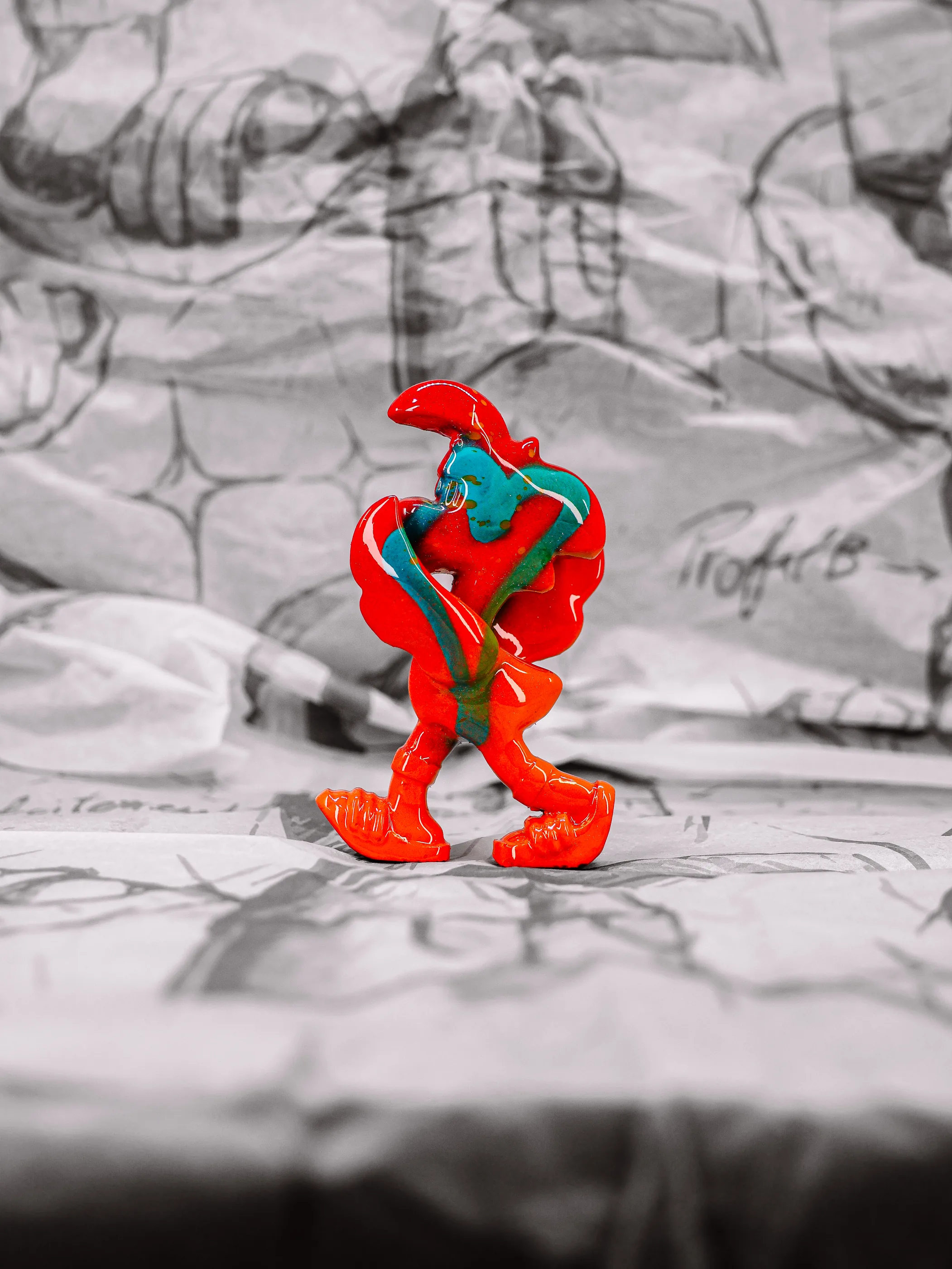Mini Roger « Orange Pressée », exemplaire rouge orangé traversé de coulures turquoise, vu de profil.