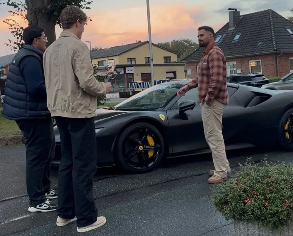 Tom Agge filmt einen Kunden vor dessen Auto in der Abendsonne