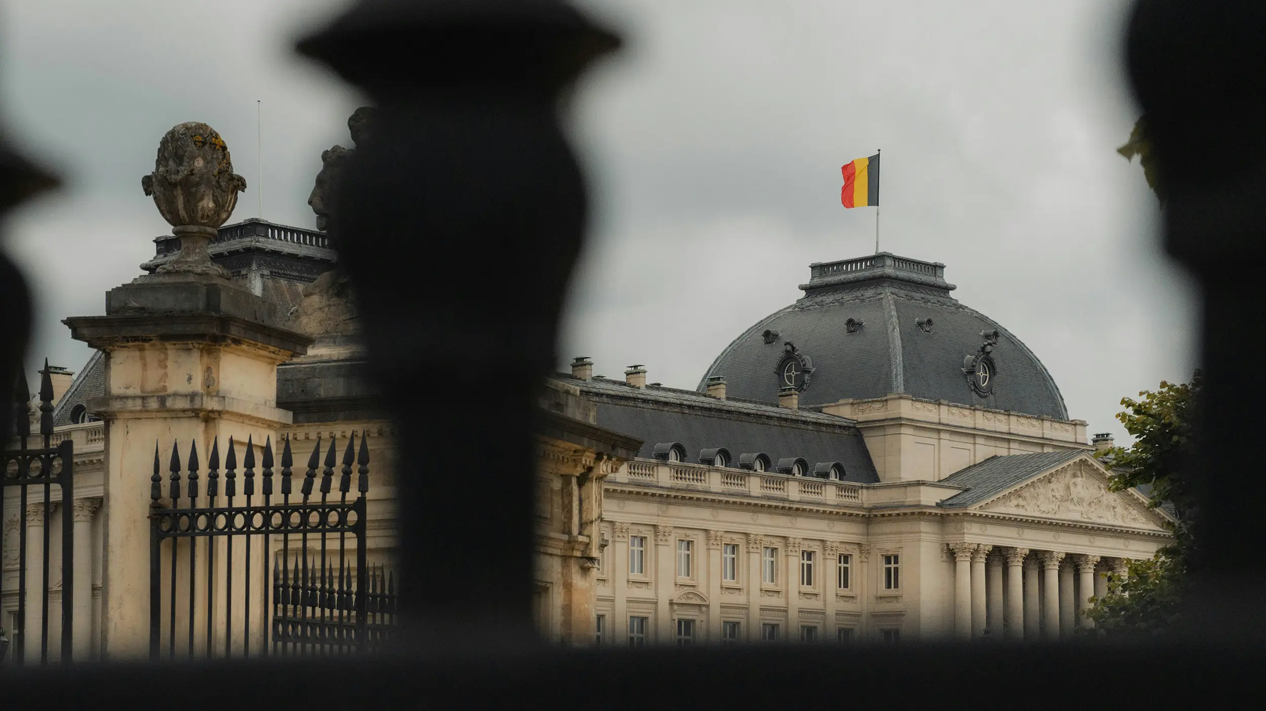 Historic government building with a Belgian flag