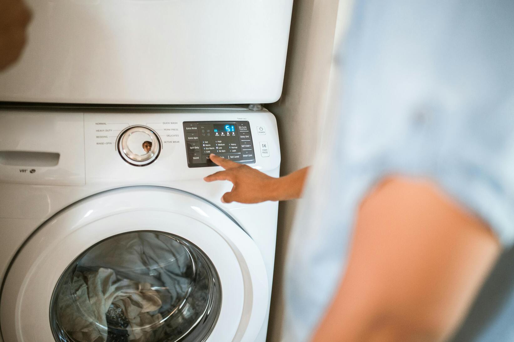 Shot of someone turning on the washer of Electrolux