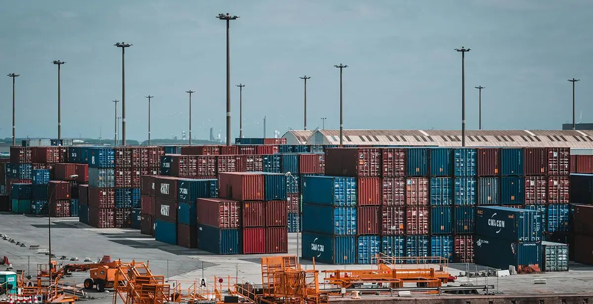 Stockimage of the top view of a harborside, lined with shipping containers.