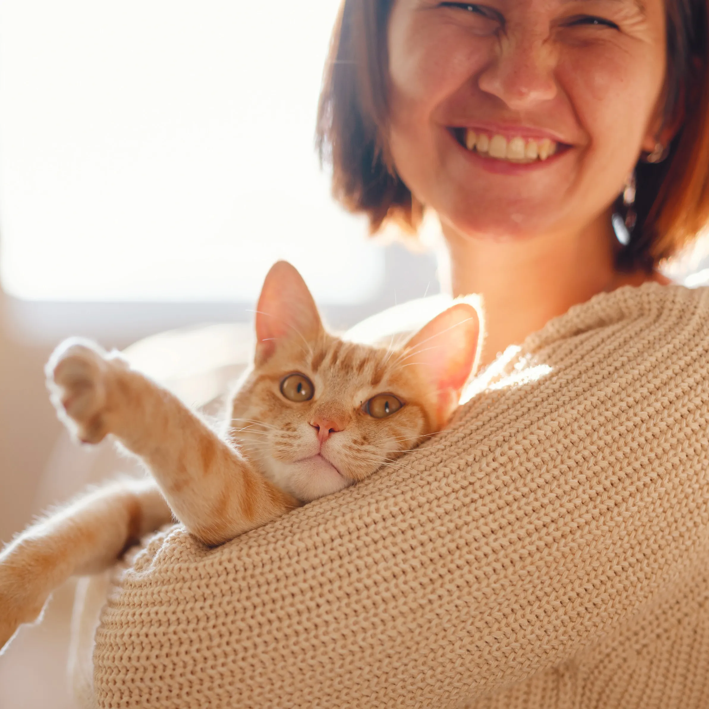 a smiling woman, holding her cat