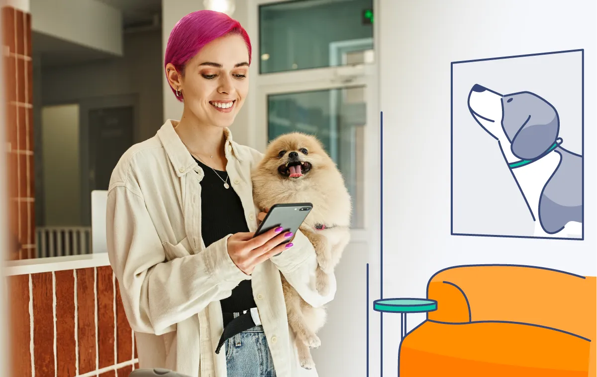 a standing woman looking at her phone while holding her dog