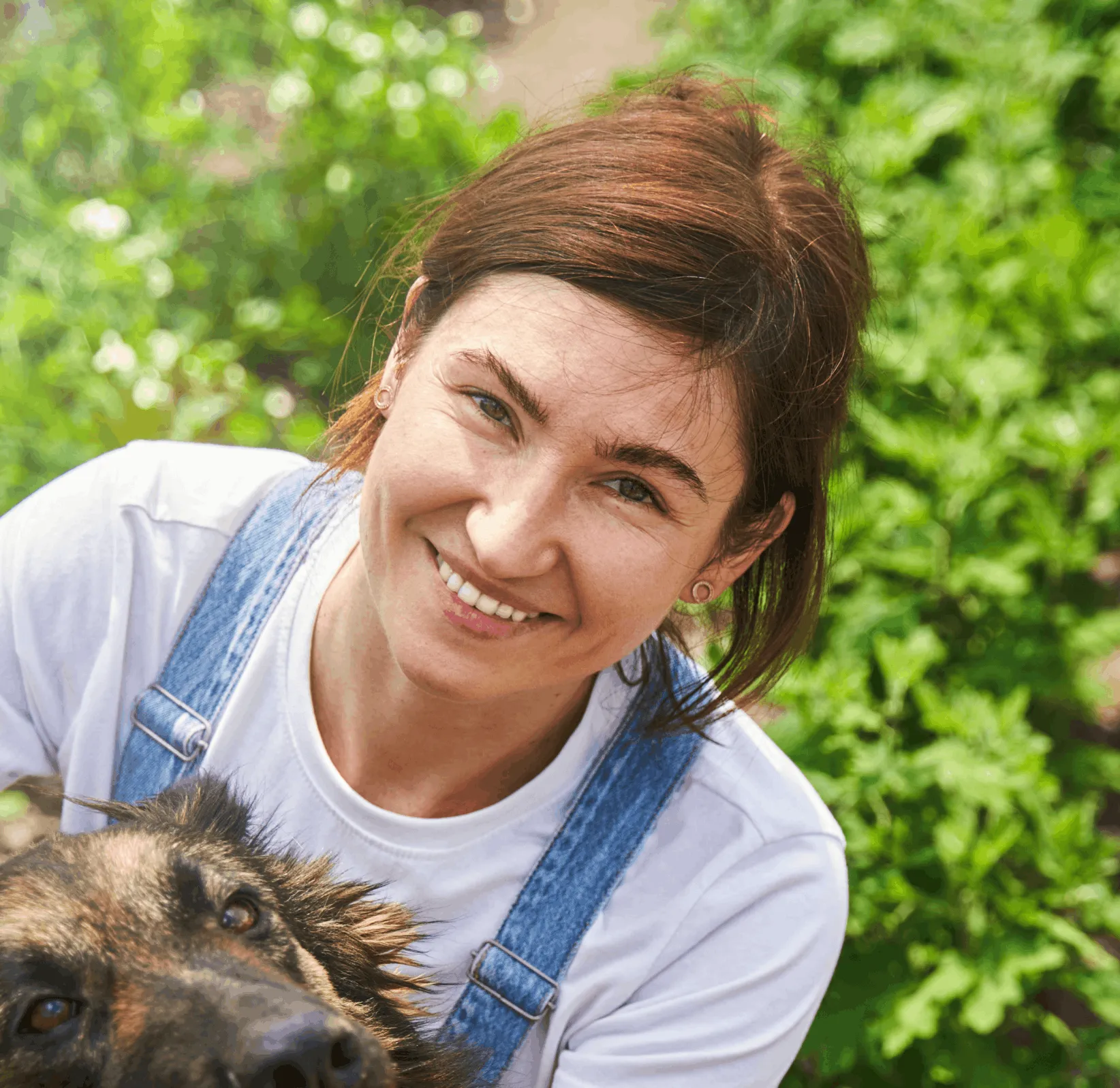 Smiling woman holding her pet outdoors