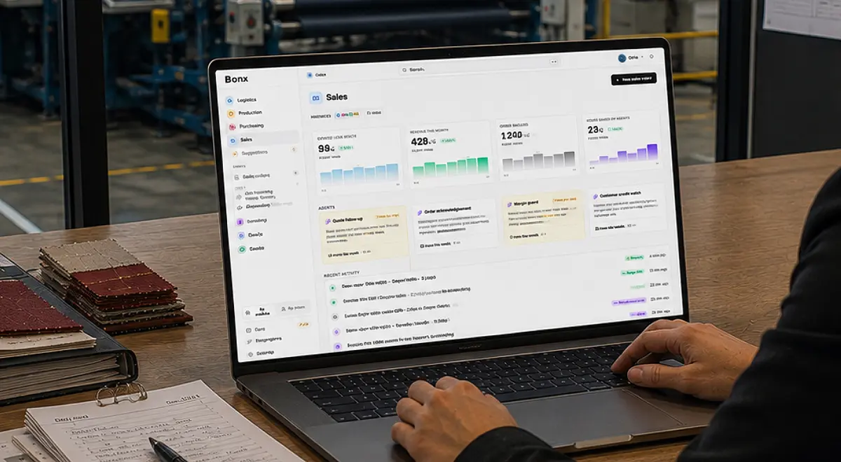 Laptop showing a Bonx sales and operations KPI dashboard on a desk scattered with material swatches.