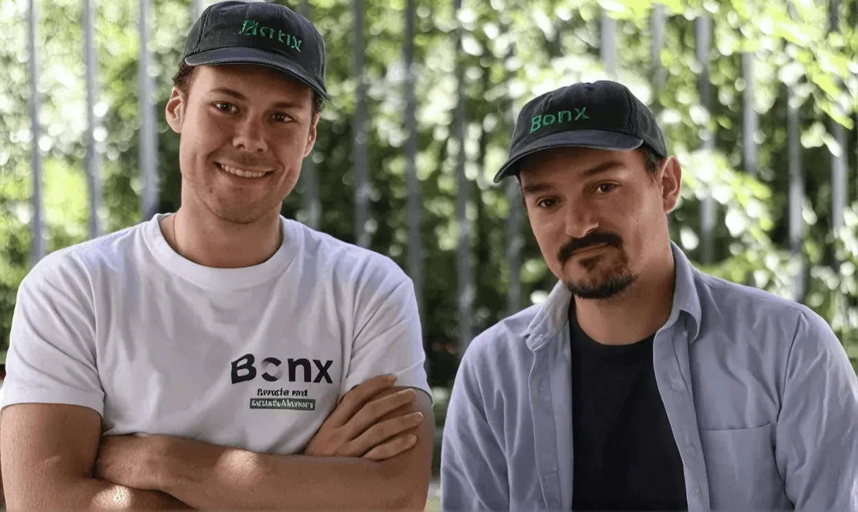 Two Bonx team members in branded caps outside a manufacturing workshop