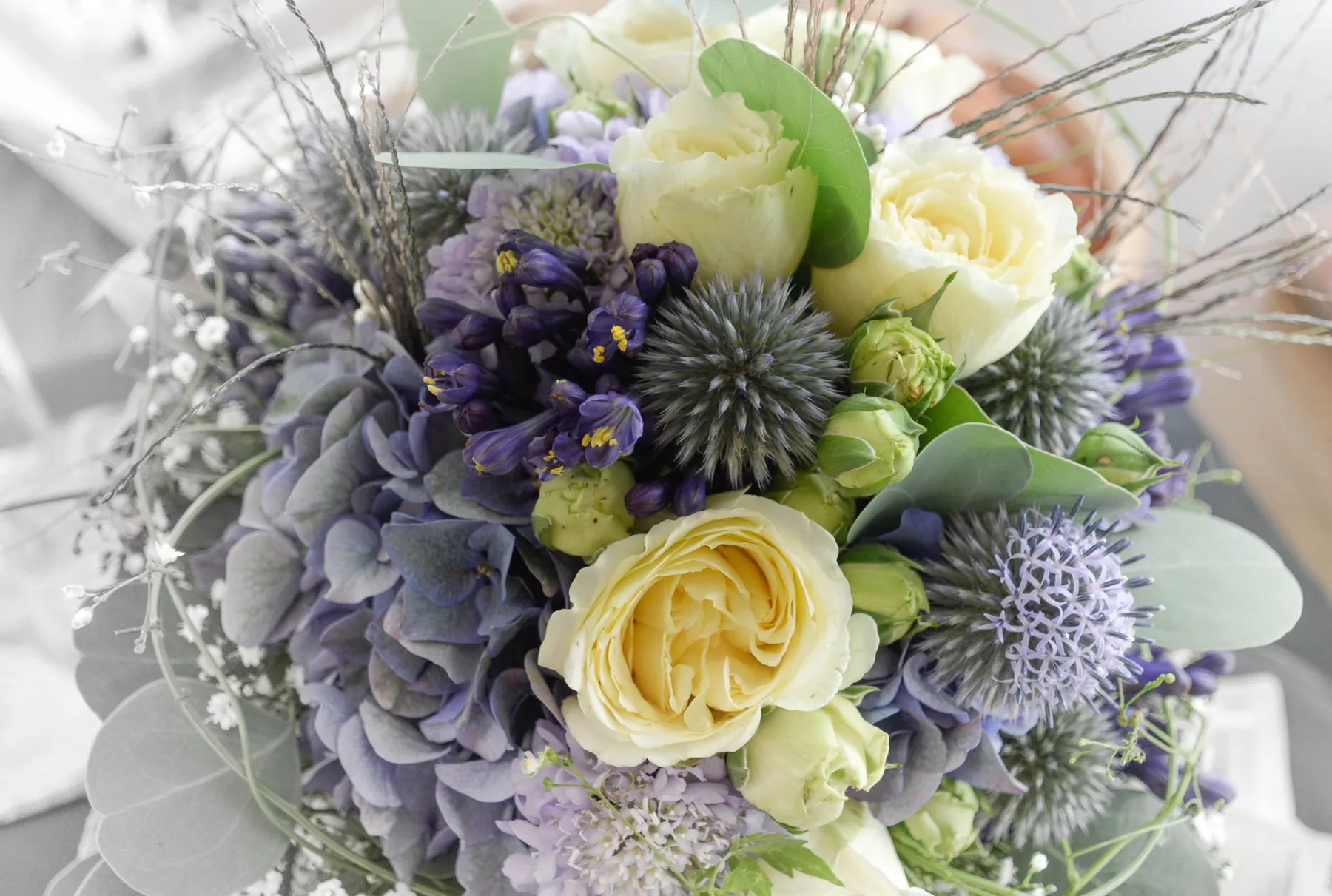 Brautstrauss mit weissen Rosen, Disteln und zarten violetten Blüten