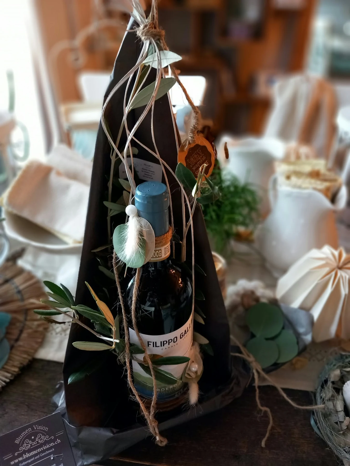 Weinflasche mit Eukalyptus und feinen floralen Details als Geschenk