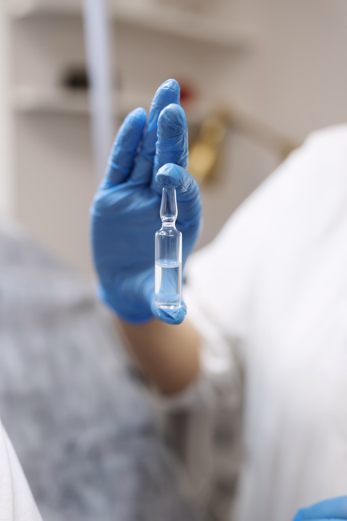 Hand mit blauem Handschuh hält eine Probe