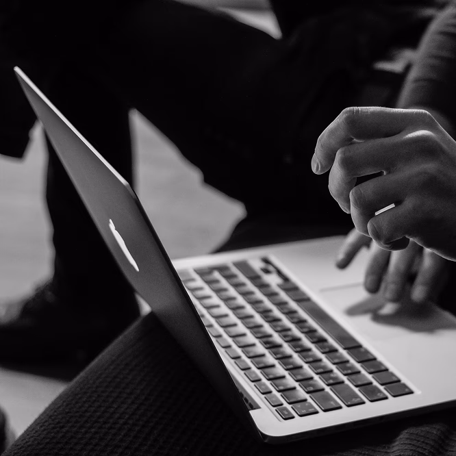 Hand tippt auf einem Laptop, Schwarz-Weiß-Aufnahme