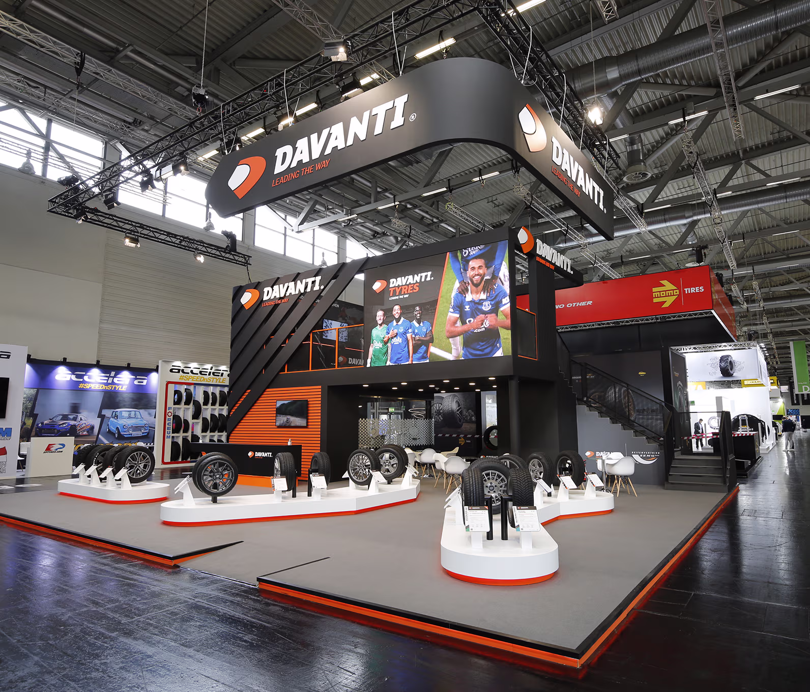 KnowBe4 exhibition booth with seating, digital screens, and illuminated logos at a trade show.