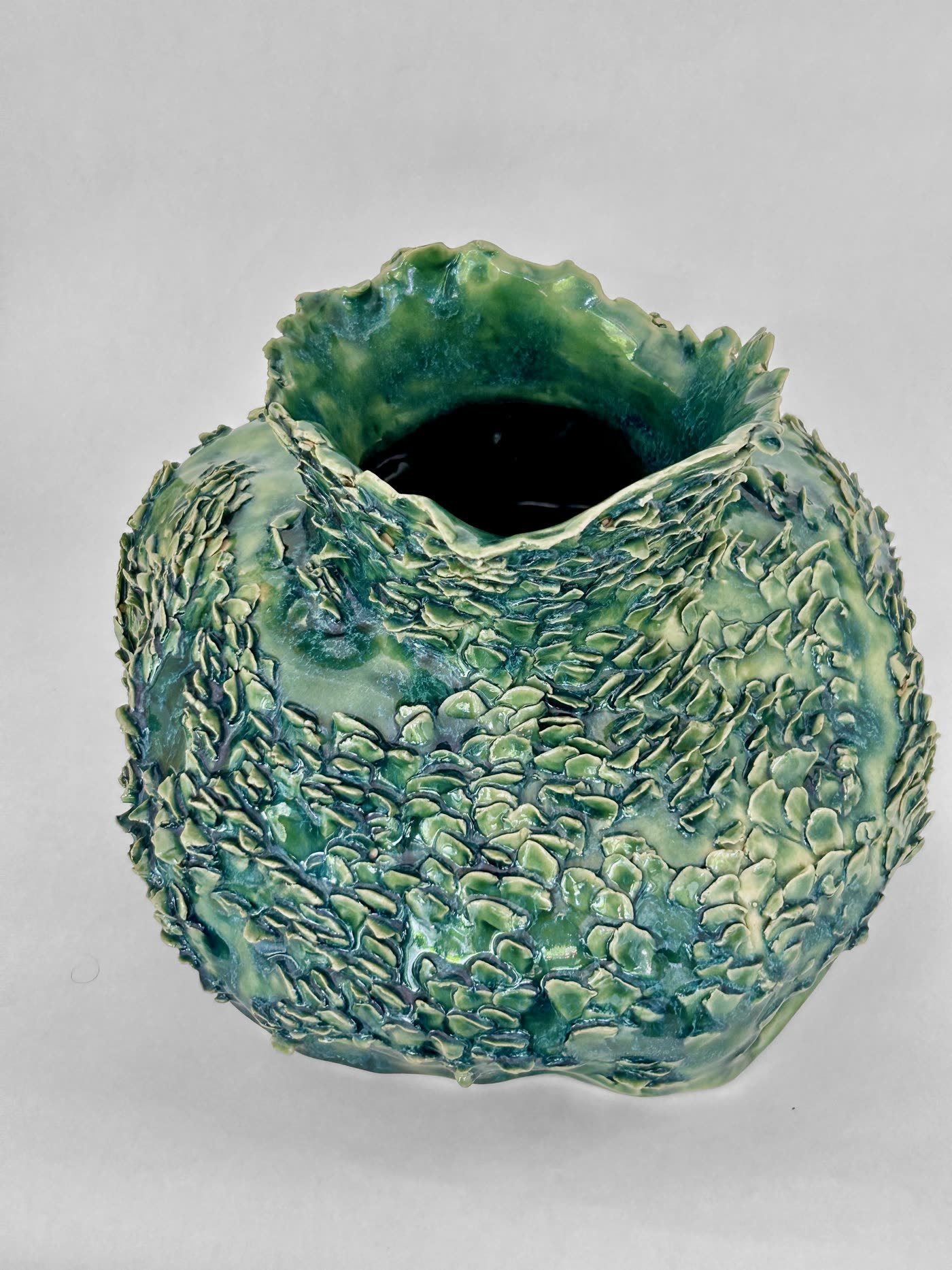 Scaled green ceramic vessel by Consuelo Becerra seen from the front, showing the open mouth, view 3 of 6
