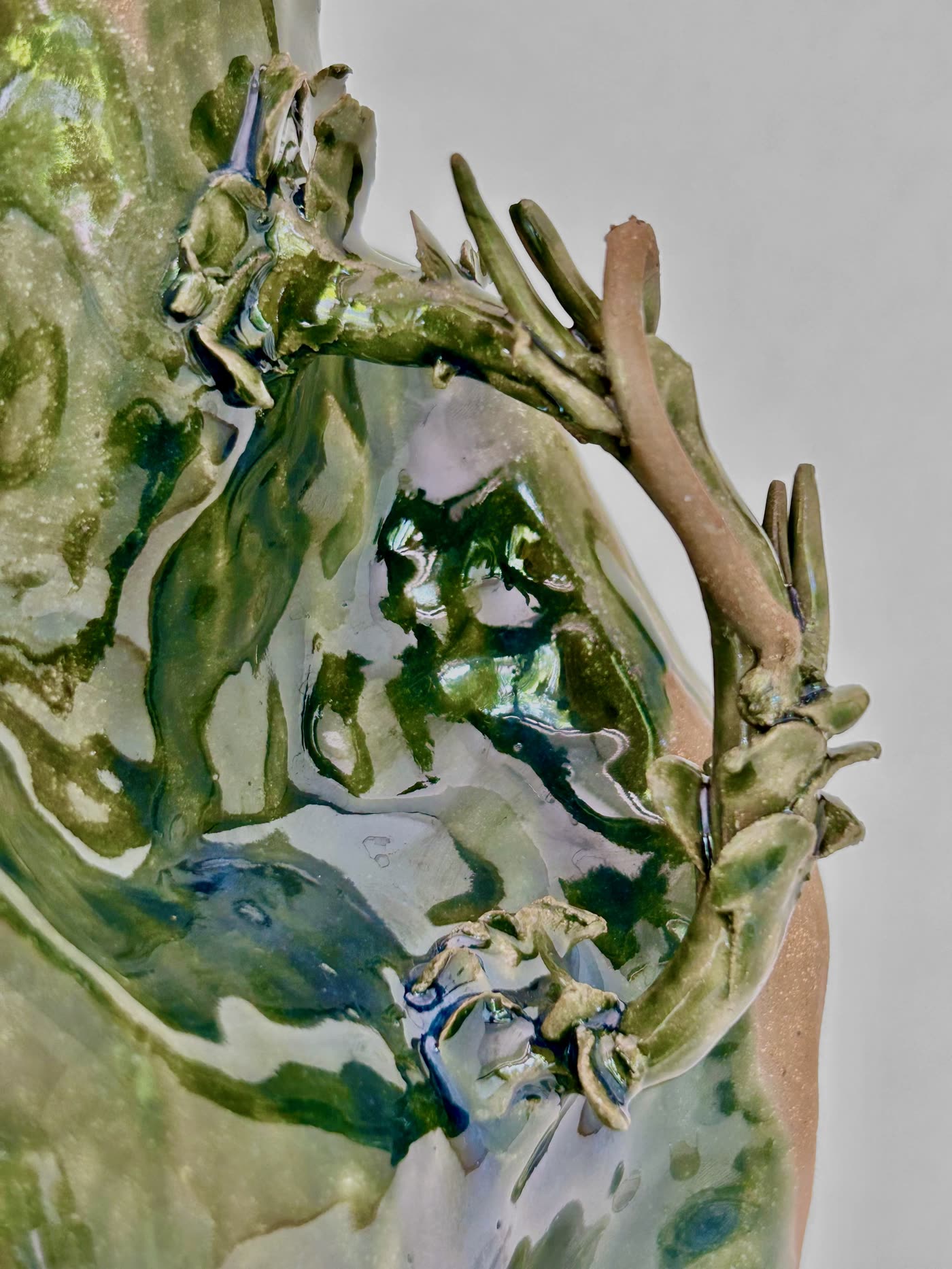 Detail of the antler-like handle on the ceramic jar by Consuelo Becerra, with modelled twigs against green glaze, view 3 of 4