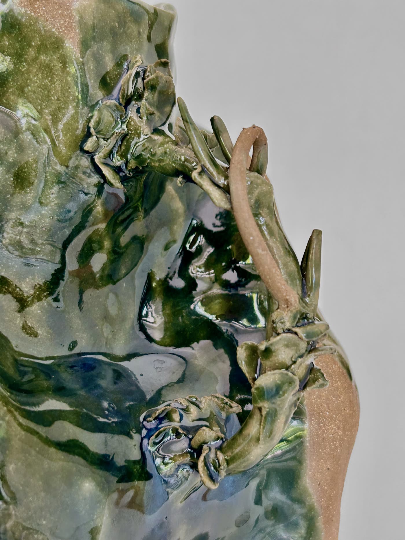 Close detail of the modelled branch handle and pooled green glaze on the jar by Consuelo Becerra, view 4 of 4