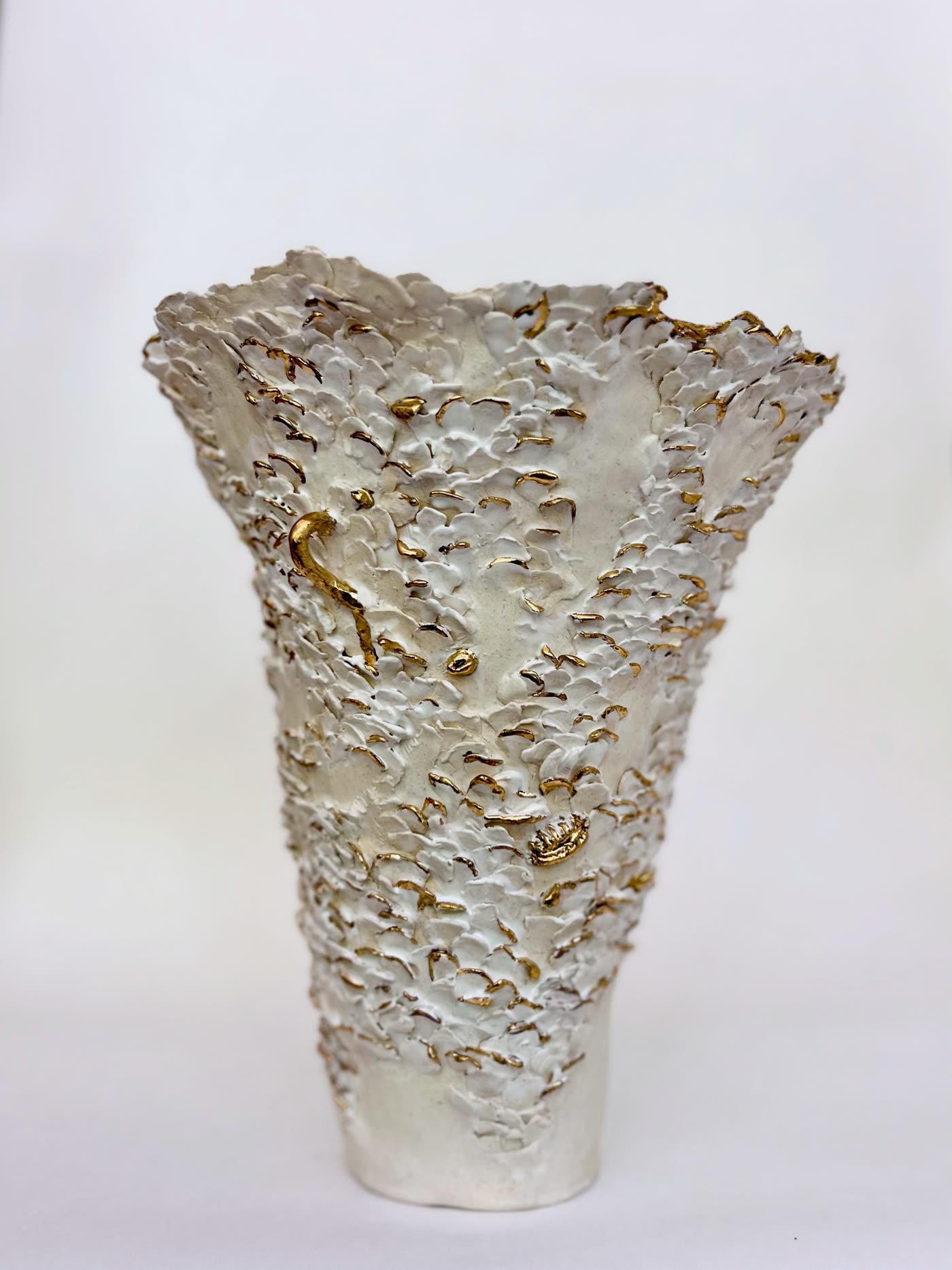 The white and gold flared vessel by Consuelo Becerra seen from the front, showing the torn ruffled rim, view 2 of 8