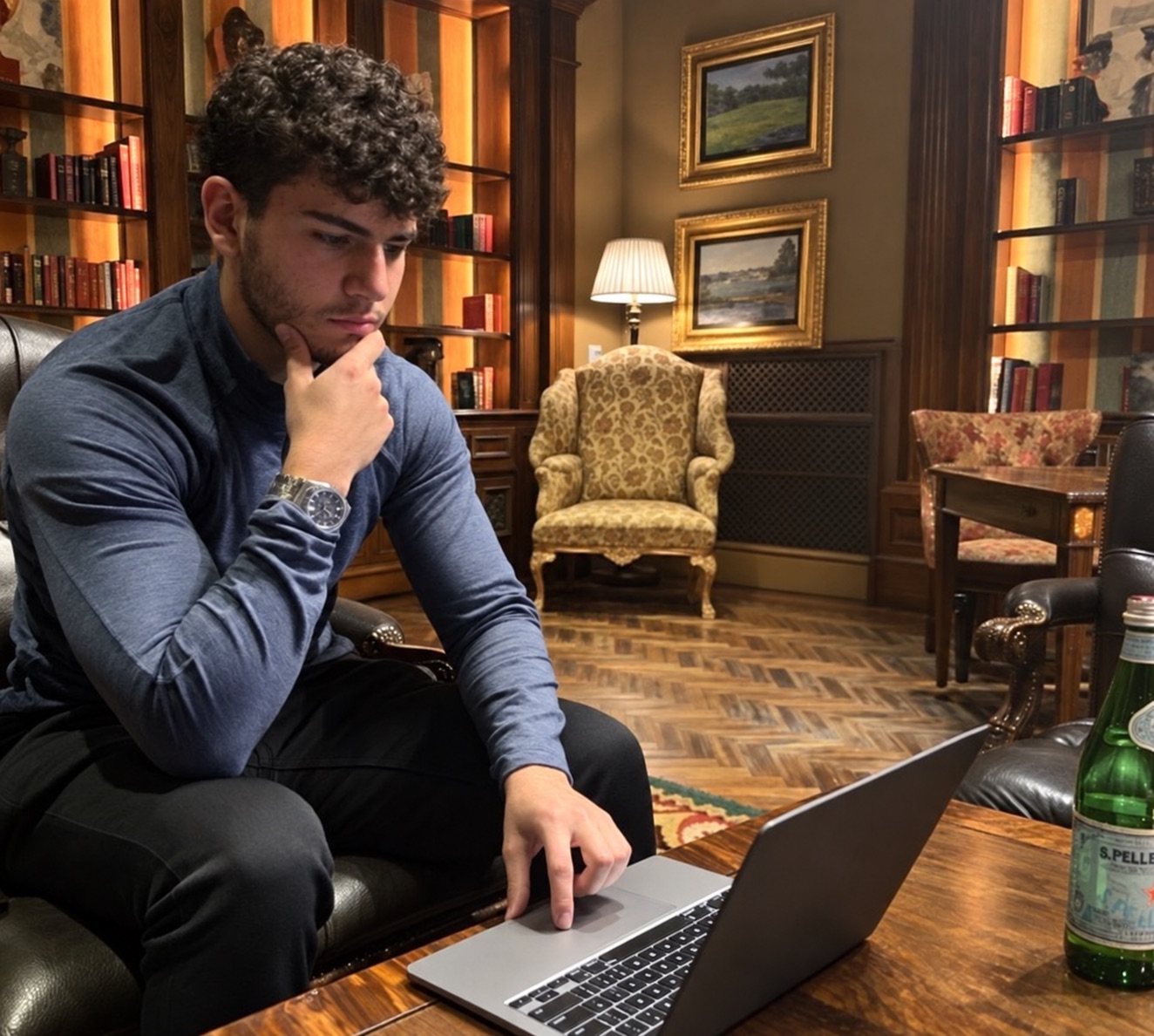Karim Naoum working at a laptop in a wood-panelled library