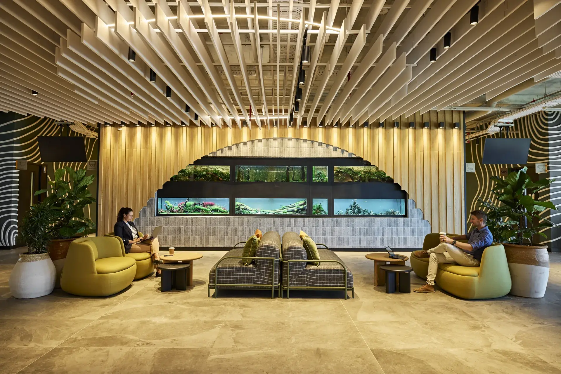 Award-winning workplace lounge with a feature aquarium wall, timber slat ceiling and soft seating.