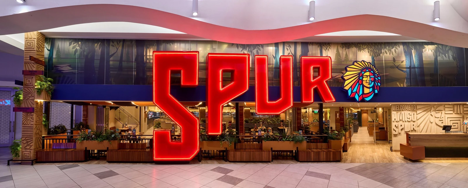 Best restaurant interior designers - Spur restaurant entrance with illuminated signage and a family-focused hospitality design layout.