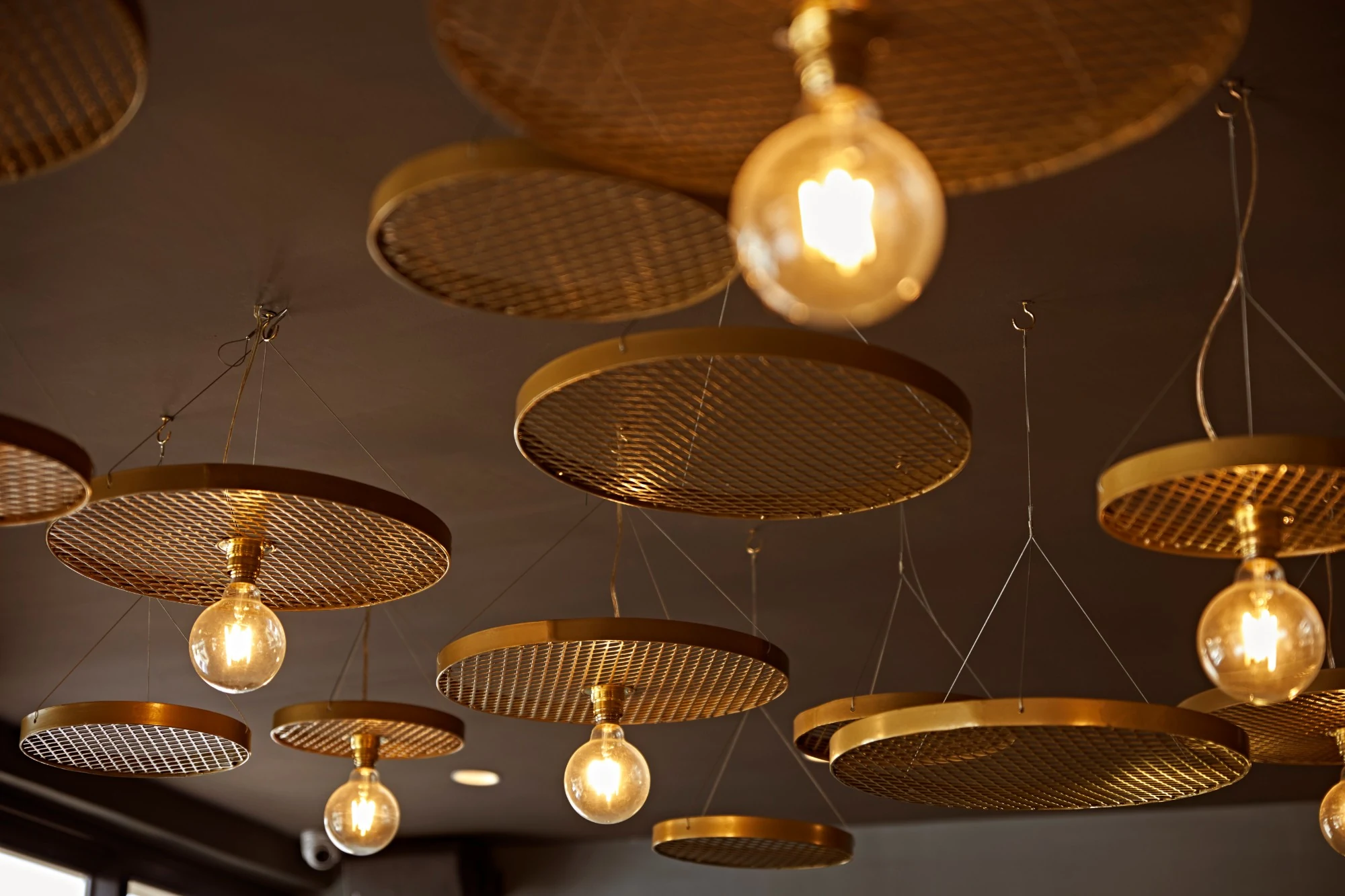 Brass mesh pendant lights over a Design Partnership hospitality interior.